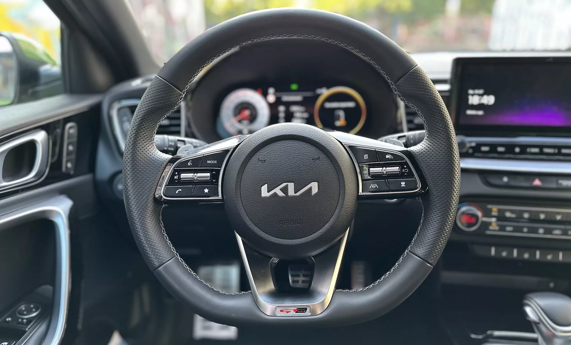 Förarens perspektivvy inuti en Kia Xceed 2022 som visar instrumentbrädan, ratten med kontrollknappar, digital-analog instrumentkluster och multimedia centerkonsol