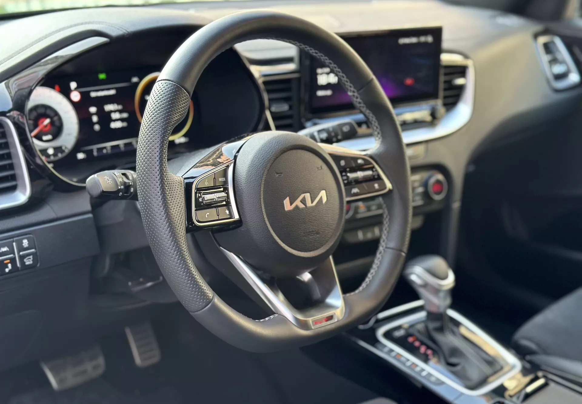 Interiör av Kia Xceed 2022 med fokus på förarsidan med ratt, digital instrumentbräda och centralt pekskärmsinfotainmentsystem som indikerar modern teknik och bekvämlighet