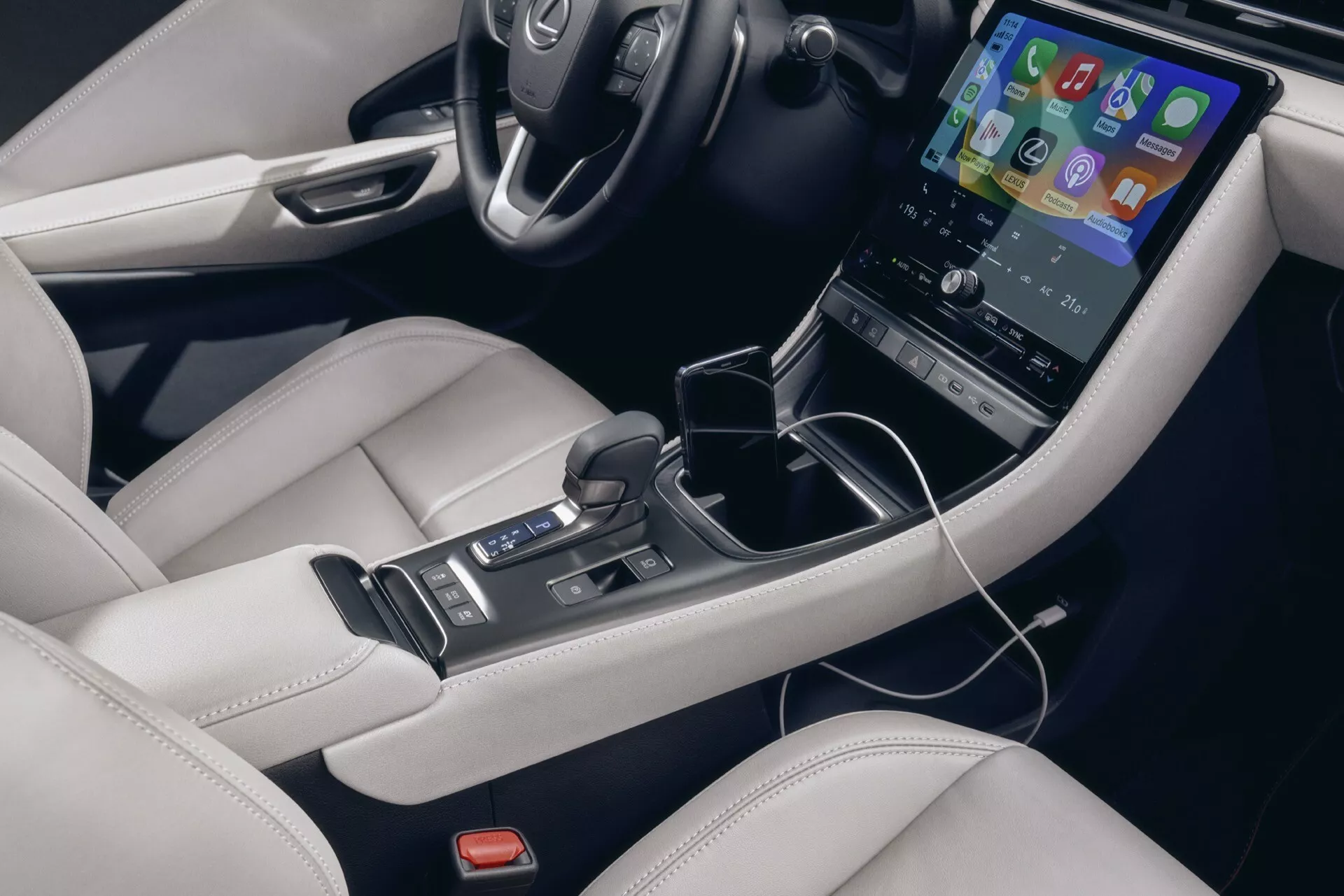 Interiör av Lexus LBX 1:a generationen 2024 som visar en detaljerad vy av mittkonsolen med en vertikal pekskärm, automatisk växelspak och lyxigt läderklädsel