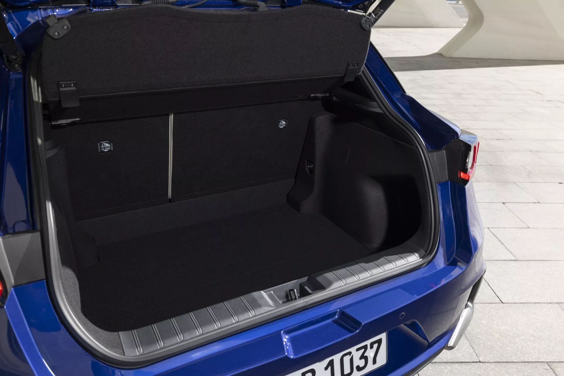 Närbild på det rymliga bagageutrymmet i den blå Lexus LBX 2024 med öppet lock, som visar interiördetaljer och designfunktioner från ett bakifrån-höger perspektiv