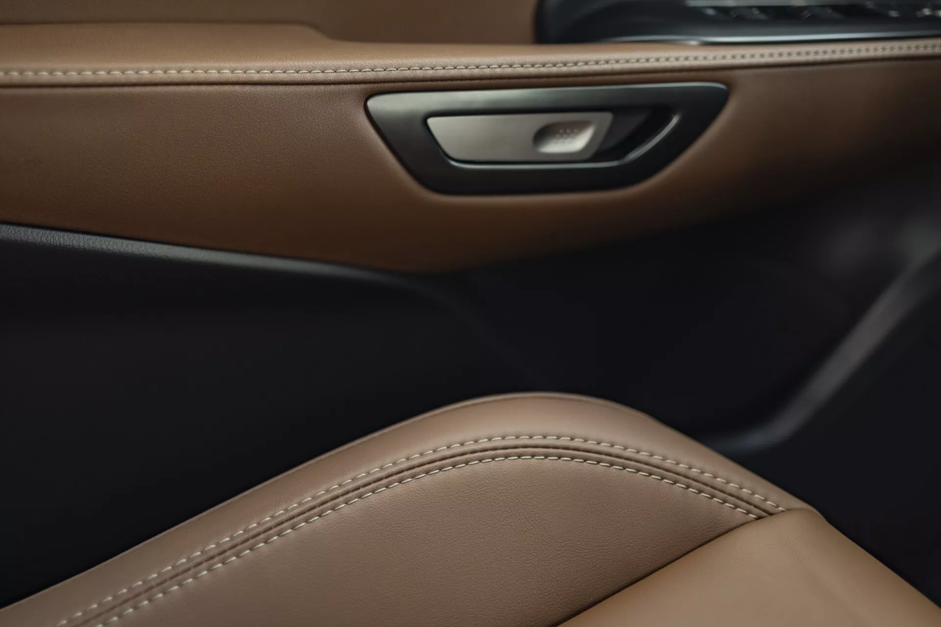 Detaljerad vy av Lexus LBX 2024 interiör som visar lyxigt brunt läderdörrfoder, ergonomisk sitsdesign och funktioner för omgivningsbelysning