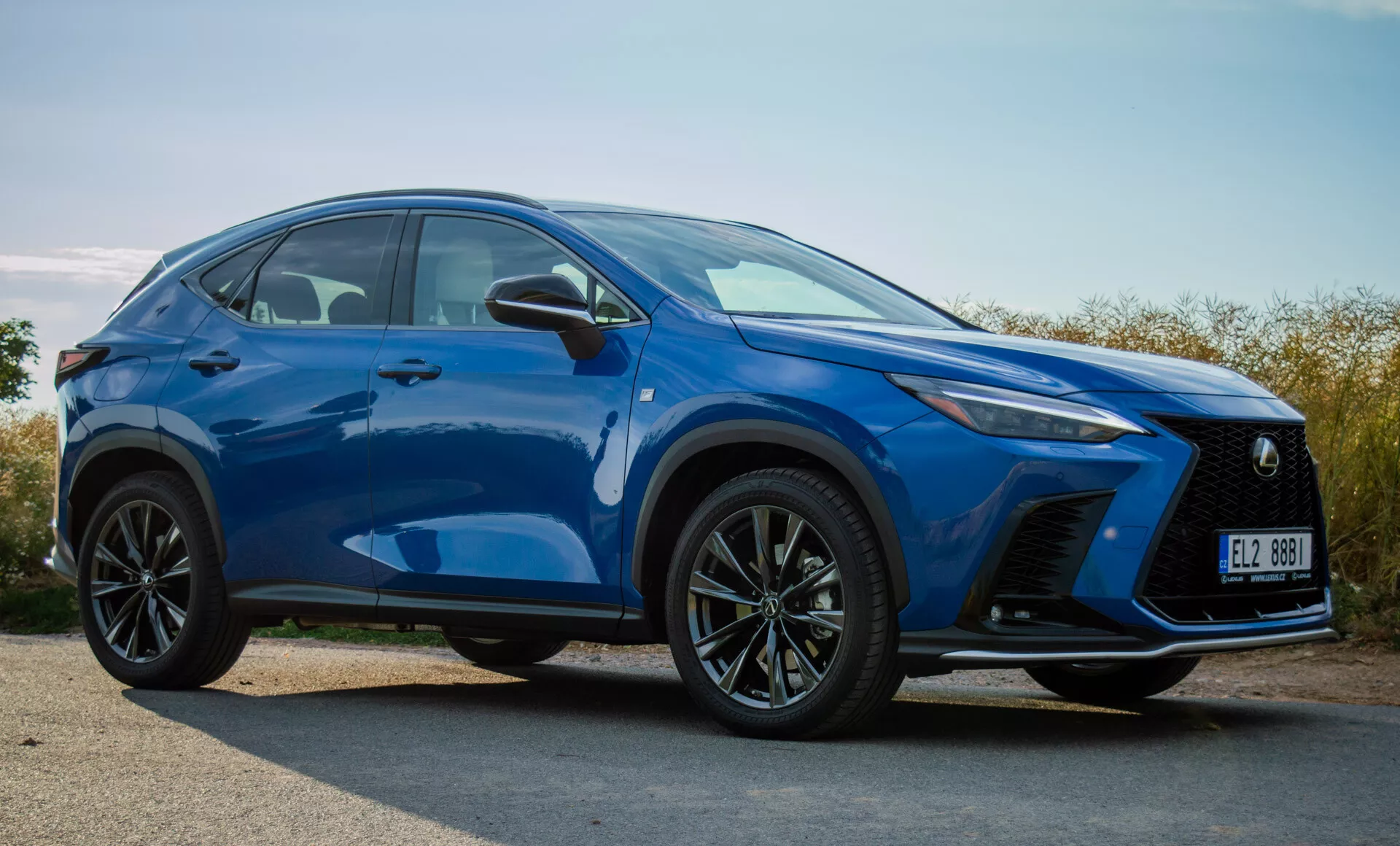 2021 Lexus NX kompakt SUV i livligt blå, visar frontkofångare, grill, LED-strålkastare, huva, hjul och sidokonturlinjer från ett tre fjärdedels främre vy utomhus i dagsljus