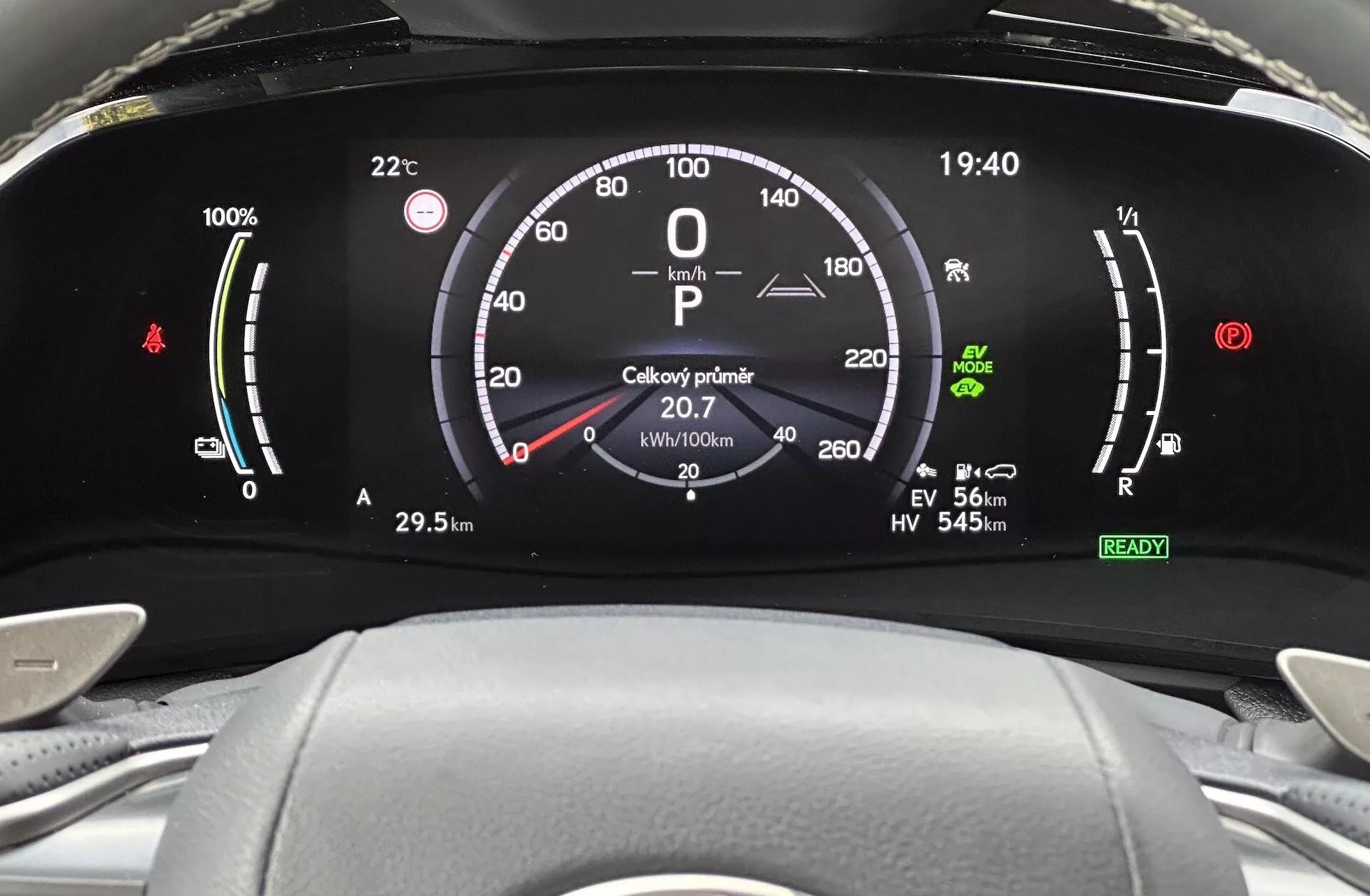 Närbild av digital instrumentpanel på Lexus NX 2021, med batteriladdningsindikator, hastighetsmätare, effektmätare och olika körlägesindikatorer ur förarens perspektiv.