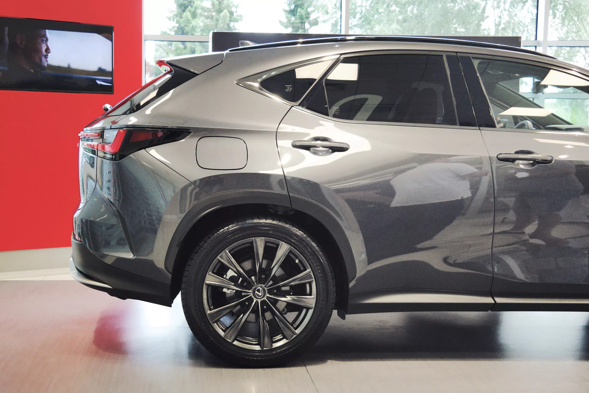 Bilden visar en trekvarts bakre vy av en modern kompakt eller mellanstor crossover-SUV, med fokus på högra sidan. Synliga funktioner inkluderar flerspakslegeringshjul, LED-bakljus, en sluttande taklinje, tonade bakre fönster, en metallisk lackering, skarpa karosslinjer, en integrerad bakspoiler, en hajfensantenn och plastdetaljer på den nedre delen av fordonet. Bilens design antyder en sportig, aerodynamisk profil, lämplig för diskussioner om fordonsdesign, teknik och funktioner.