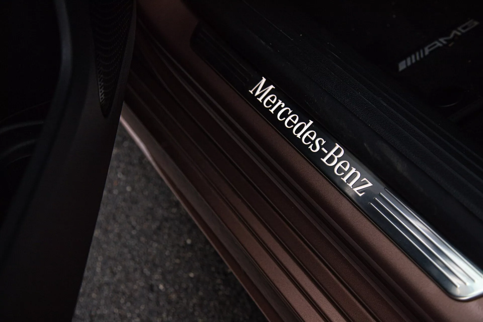 Närbild av tröskeln till dörren på Mercedes-Benz A-Klass 2022 med metalliska bokstäver Mercedes-Benz och AMG på en premiumfinish
