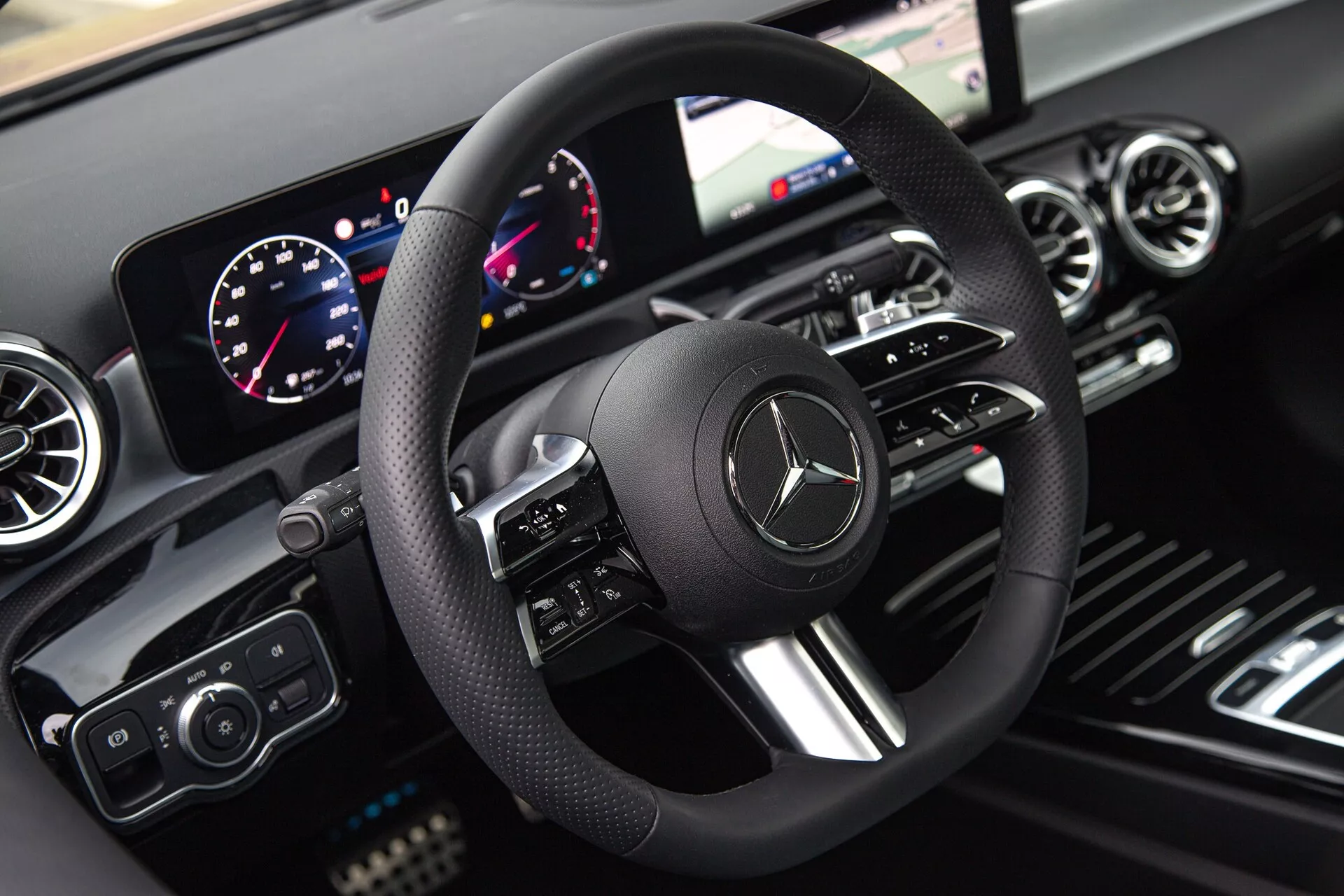 Interiör av Mercedes-Benz A-Klass 2022 som visar förarens vy över ratt, digital instrumentbräda och infotainmentsystem som betonar modern teknik och lyxig design