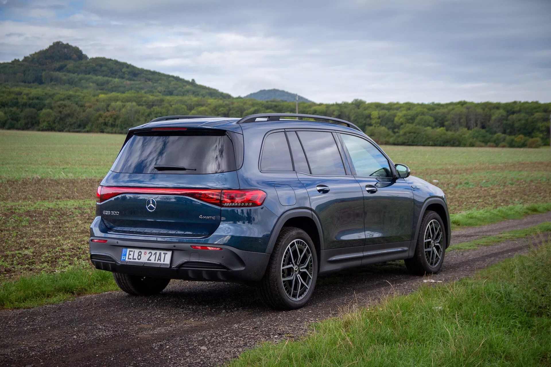Elektrisk SUV Mercedes-Benz EQB modell 2021 i silver på en motorväg med klar himmel i bakgrunden
