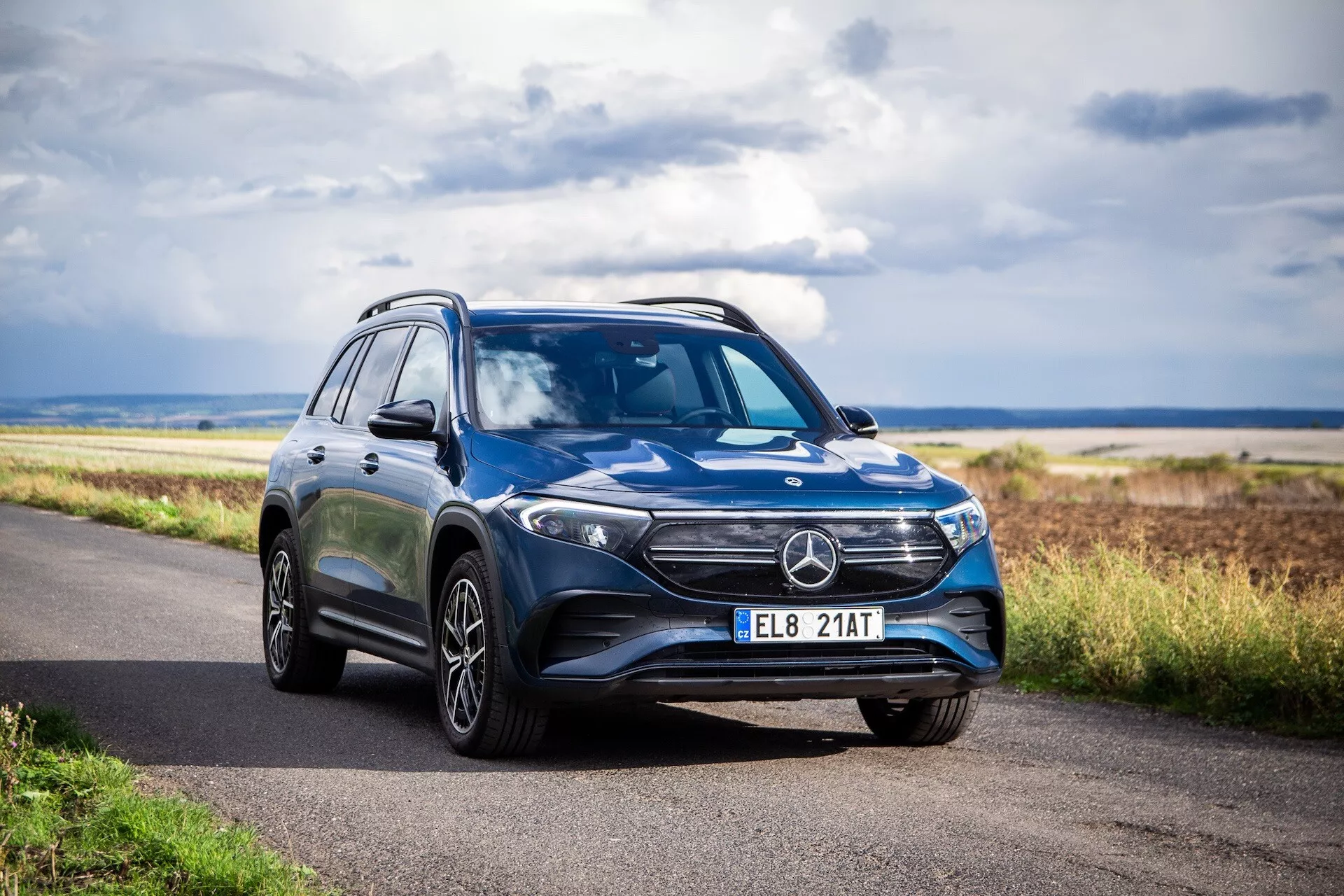 Lyxig SUV Mercedes-Benz EQB 2021 parkerad på en asfalterad väg, som visar upp sin slanka design, LED-strålkastare och legeringshjul i en tre fjärdedels vy under en klar himmel
