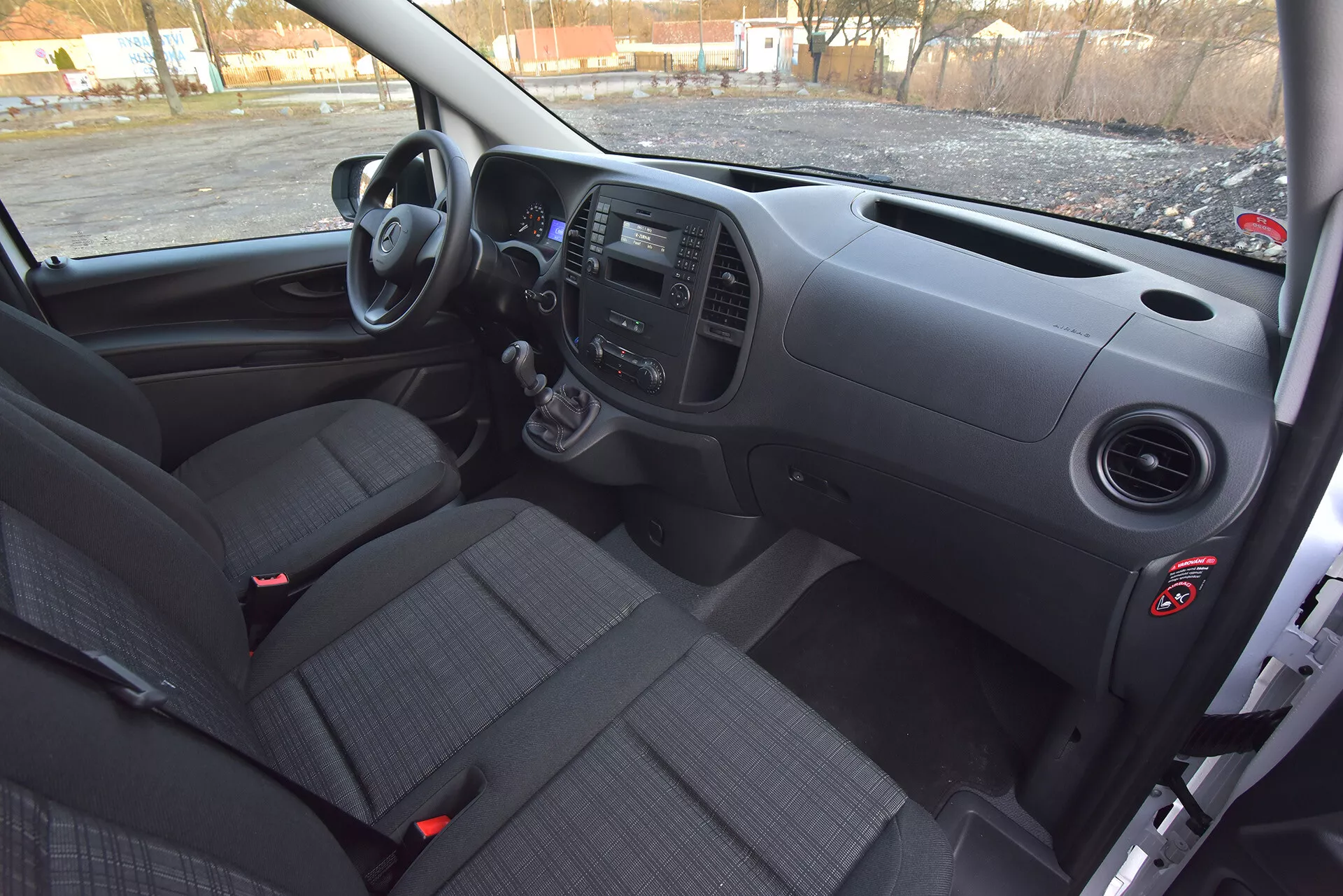 Interiörvy av Mercedes-Benz Vito Tourer från 2014 från förarsidan som visar främre instrumentbrädan, manuell växellåda, kontrollpaneler och tygsäten