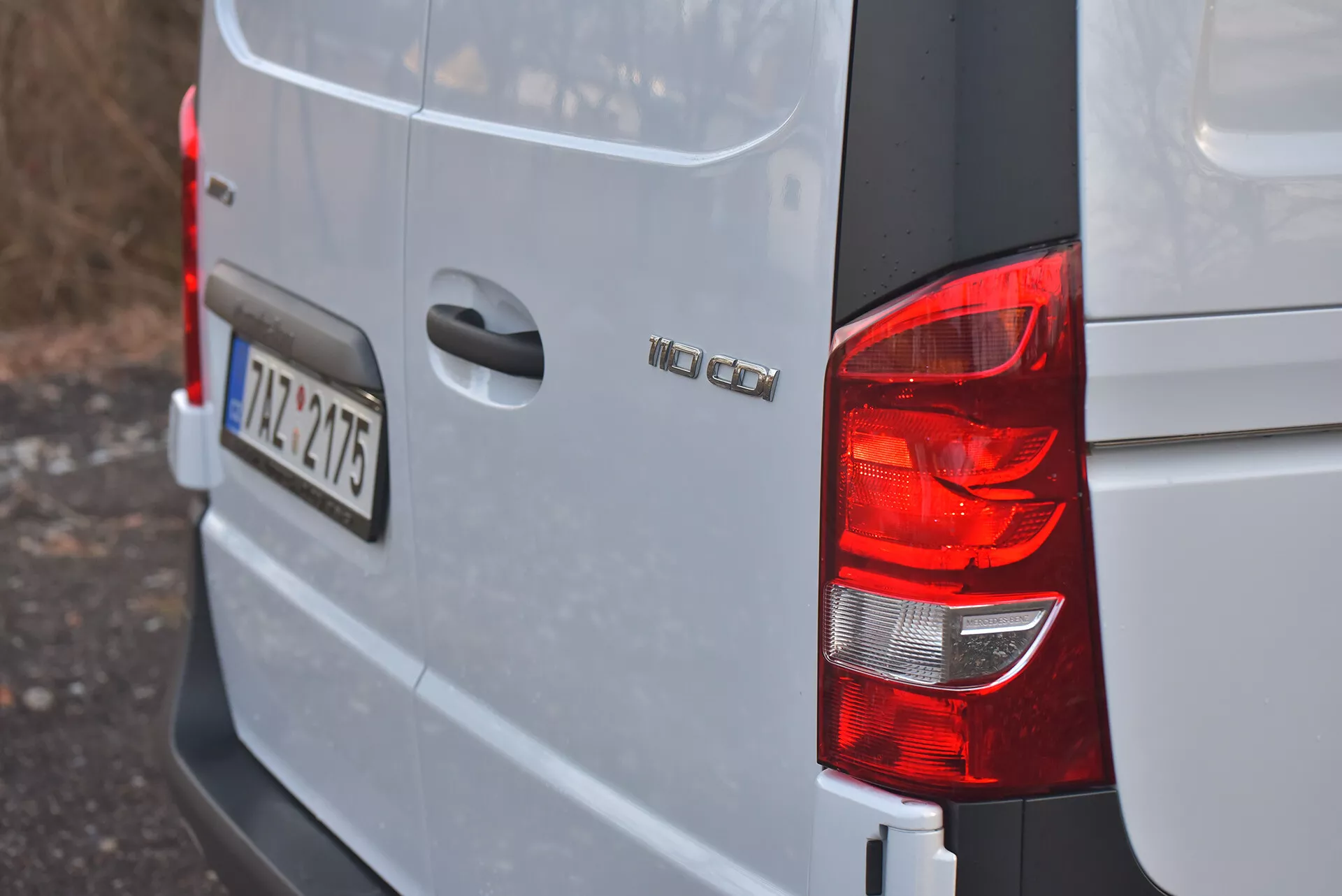 Bakre högra hörnvyn av en silver eller ljusgrå Volkswagen Vito 2014 Tourer som visar bakljus, modellmärke 'VW CADDY', europeiskt registreringsskylt '12-TZ-4715', och kantig karossdesign typisk för kompakta lastbilar.