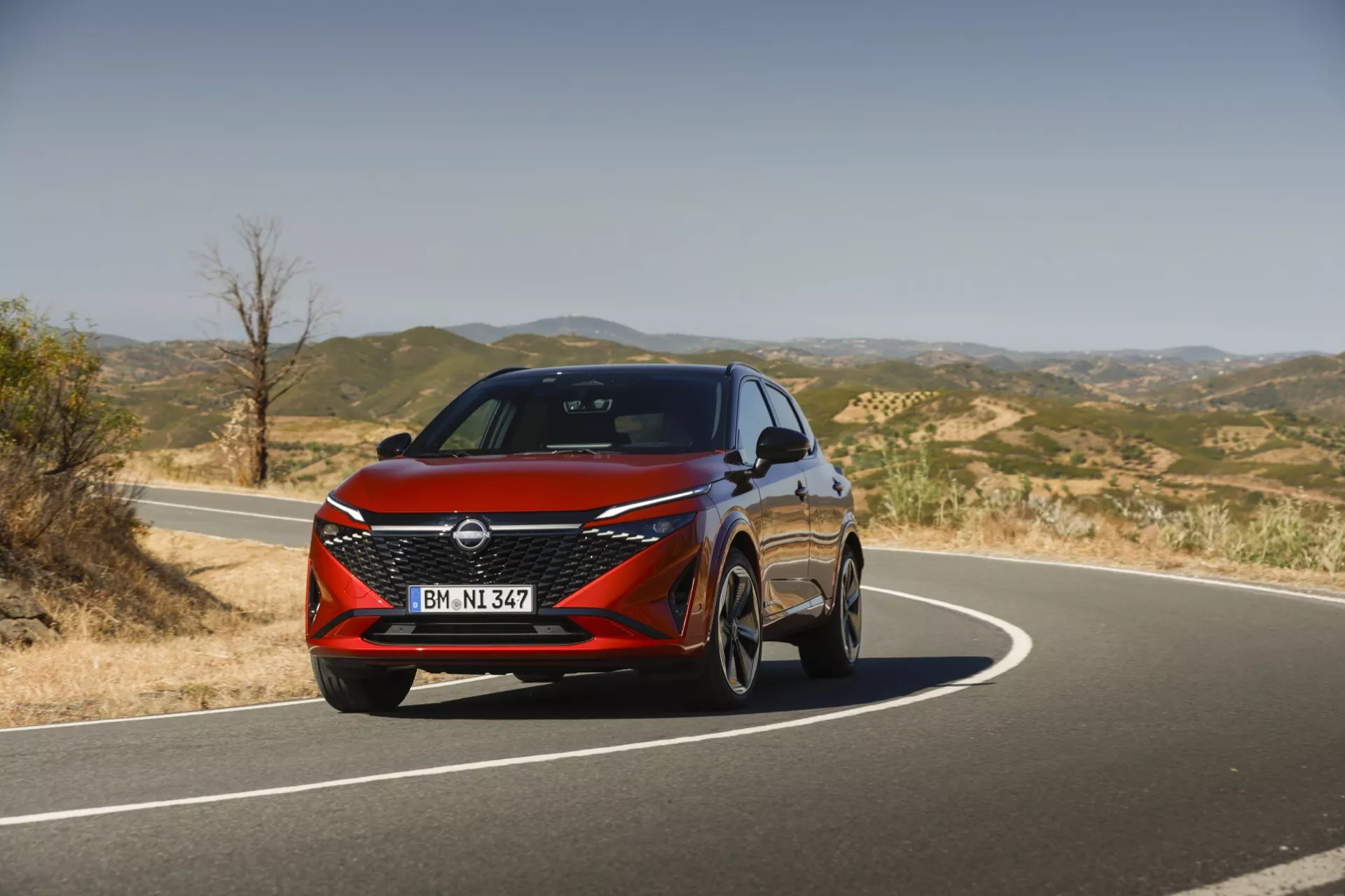 Främre vy av Nissan Qashqai 2024 J12-facelift som visar dess moderna design med eleganta LED-strålkastare, ett djärvt V-motion främre galler och dynamiska linjer som betonar dess sportiga och sofistikerade estetik.