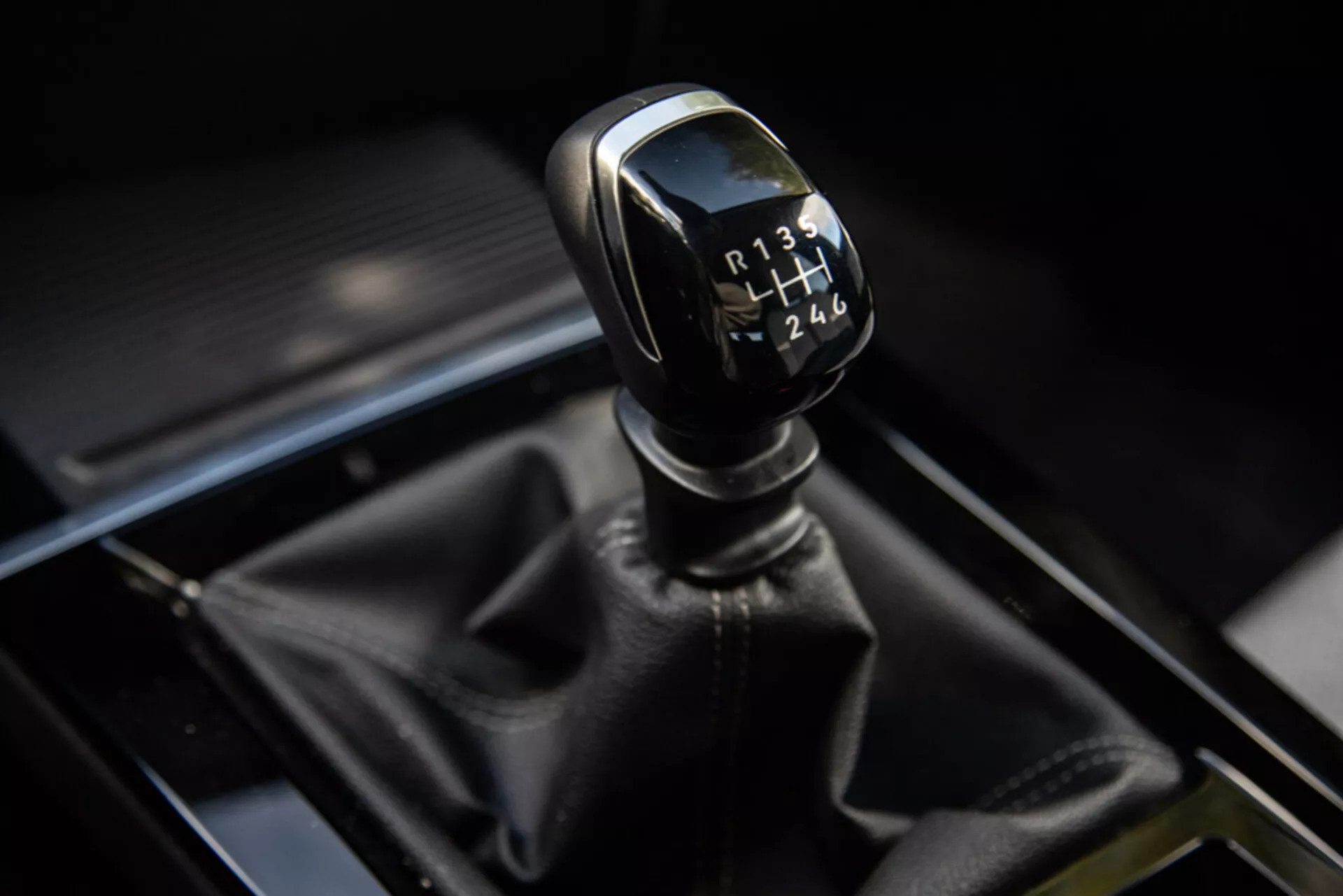 Närbild av en 2022 Opel Astras manuell växelspak med 6-växlad mönster och bakåt, som visar växelspaksknoppens detaljer och omgivande område