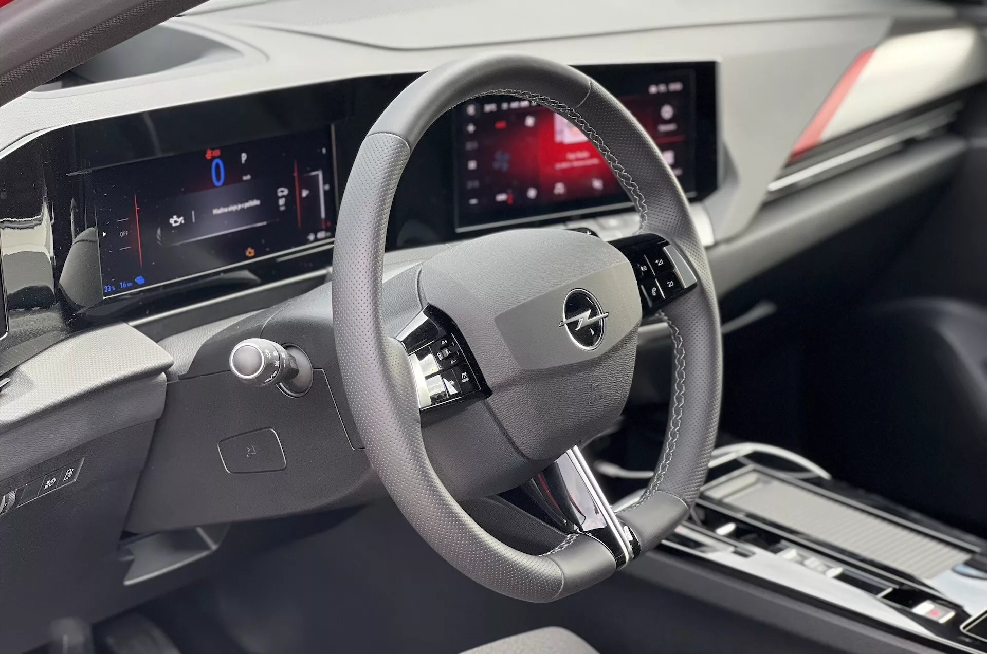 Interiörvy av en Opel Astra 2022 med fokus på förarområdet med detaljerat ratt, digital instrumentpanel och centralt infotainmentskärm