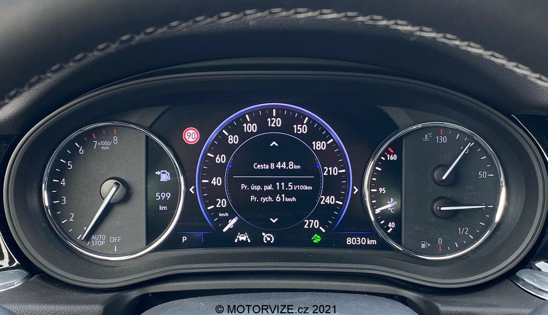 Närbild av instrumentbrädan från förarens perspektiv i en Opel Insignia 2020 Insignia-GSi Grand Sport. Brädan visar en blandning av analoga och digitala komponenter, inklusive bränslenivå, information om automatisk start-stopp-system, stor hastighetsmätare med km/h och mph markeringar, trippdata, körfältsassistentindikatorer, motorns varvmätare med röd markering vid 6500 RPM och flera varningslampor. Växelindikatorn visar 'P' för parkering. Vattenstämpel 'MOTORVIZE.cz 2021'.