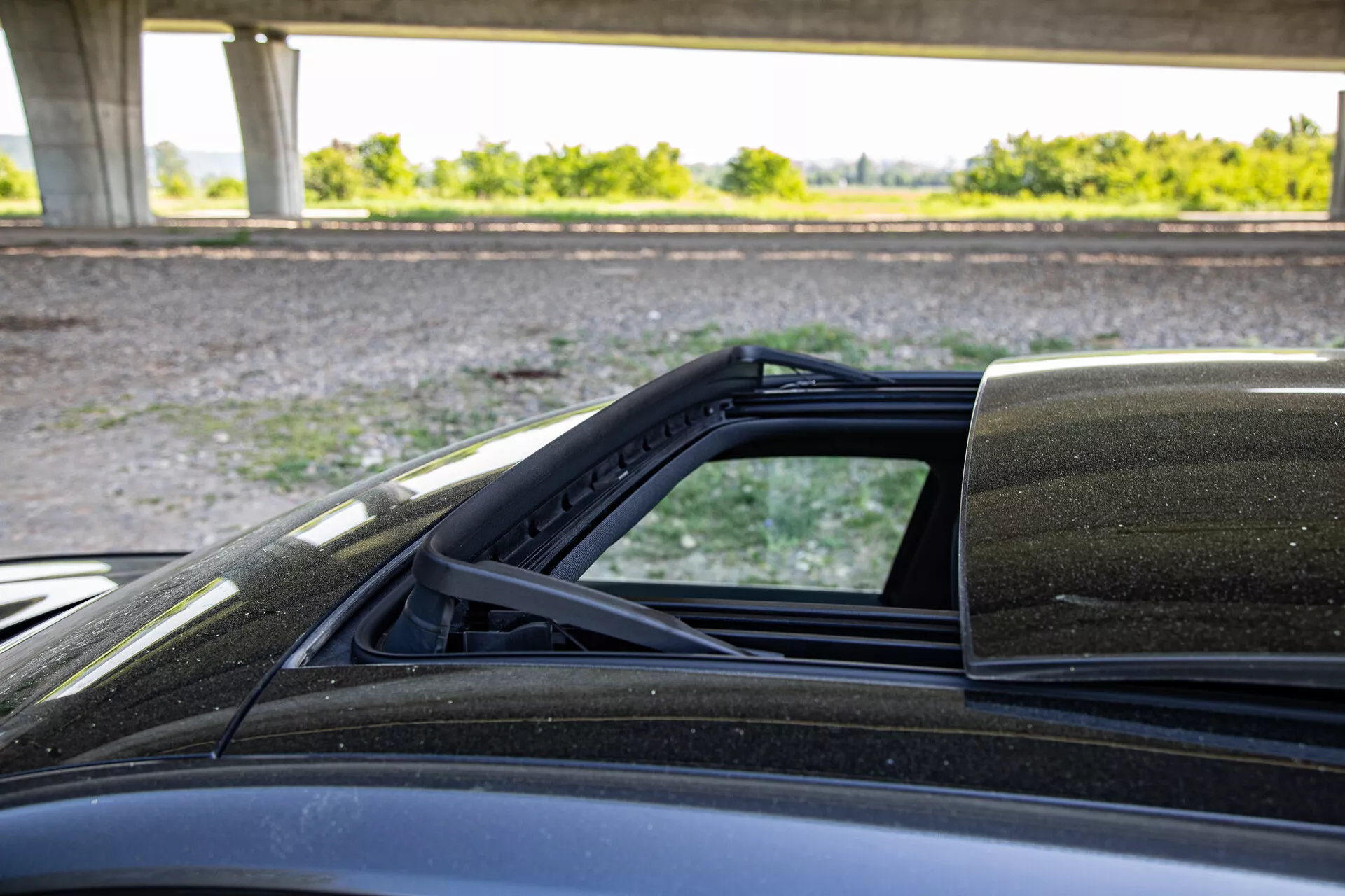 Detaljerad vy av mekanismen för det konvertibla taket på Peugeot 408 2023, fokuserad på anslutningspunkterna till karossen, tagen från passagerarsidan och framhäver soft tops inre foder, väderskyddet och yttre lackering.