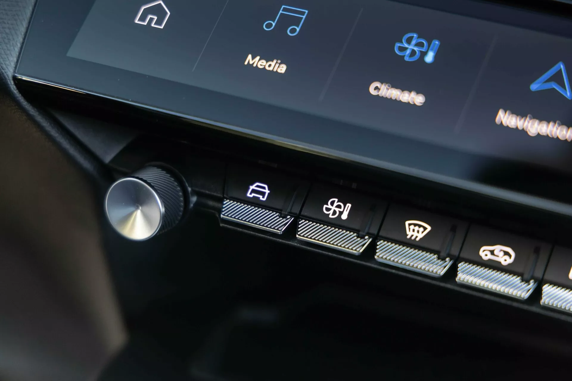 2023 Peugeot 408 centrala kontrollgränssnittet visar belysta taktila knappar och en del av pekskärmsdisplayen med infotainment- och klimatkontrollikoner, och visar avancerad fordonsteknik