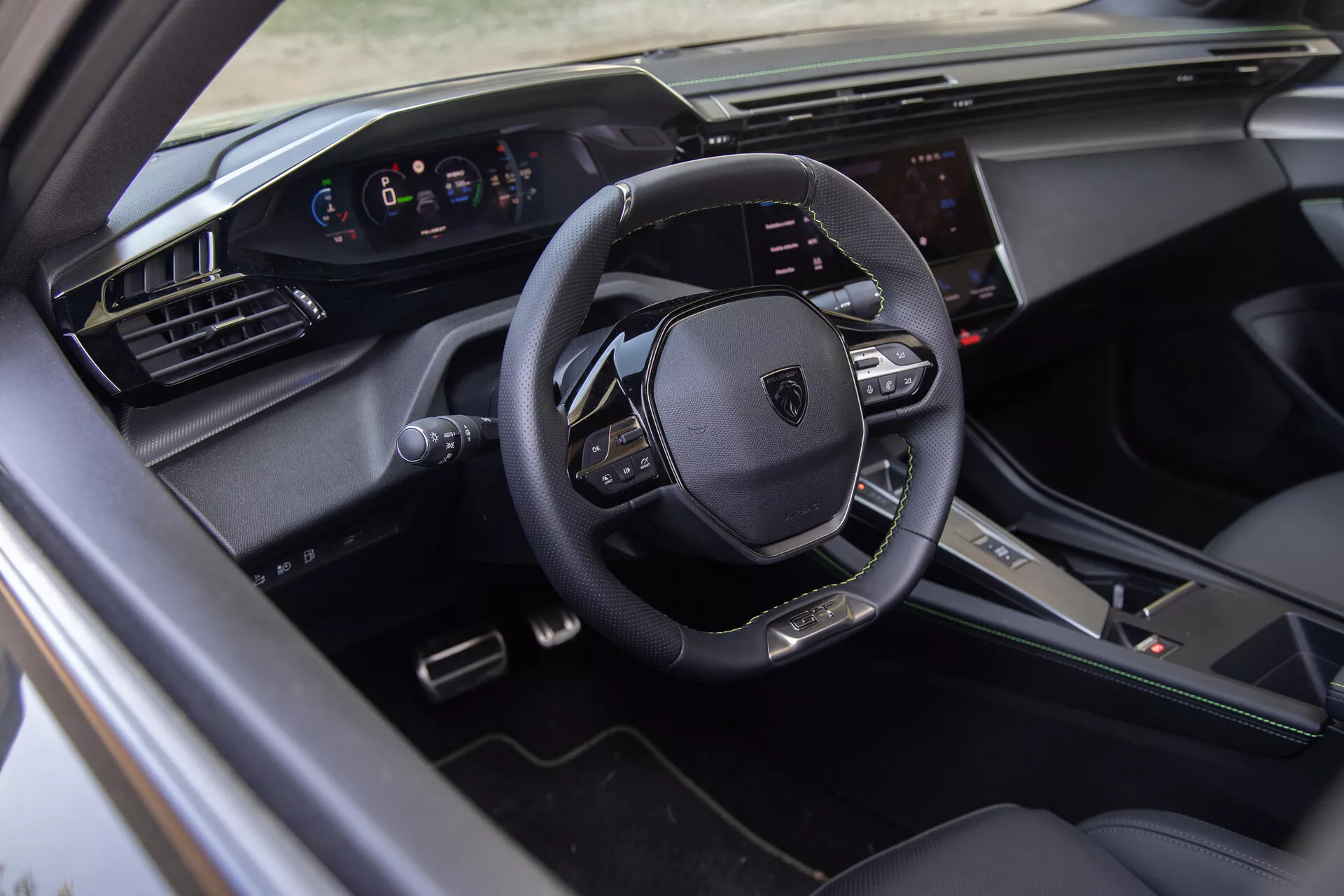 Interiör av Peugeot 408 2023 som visar en läderinbunden multifunktionsratt, digital instrumentkluster och pekskärms infotainmentsystem från förarsidans vy