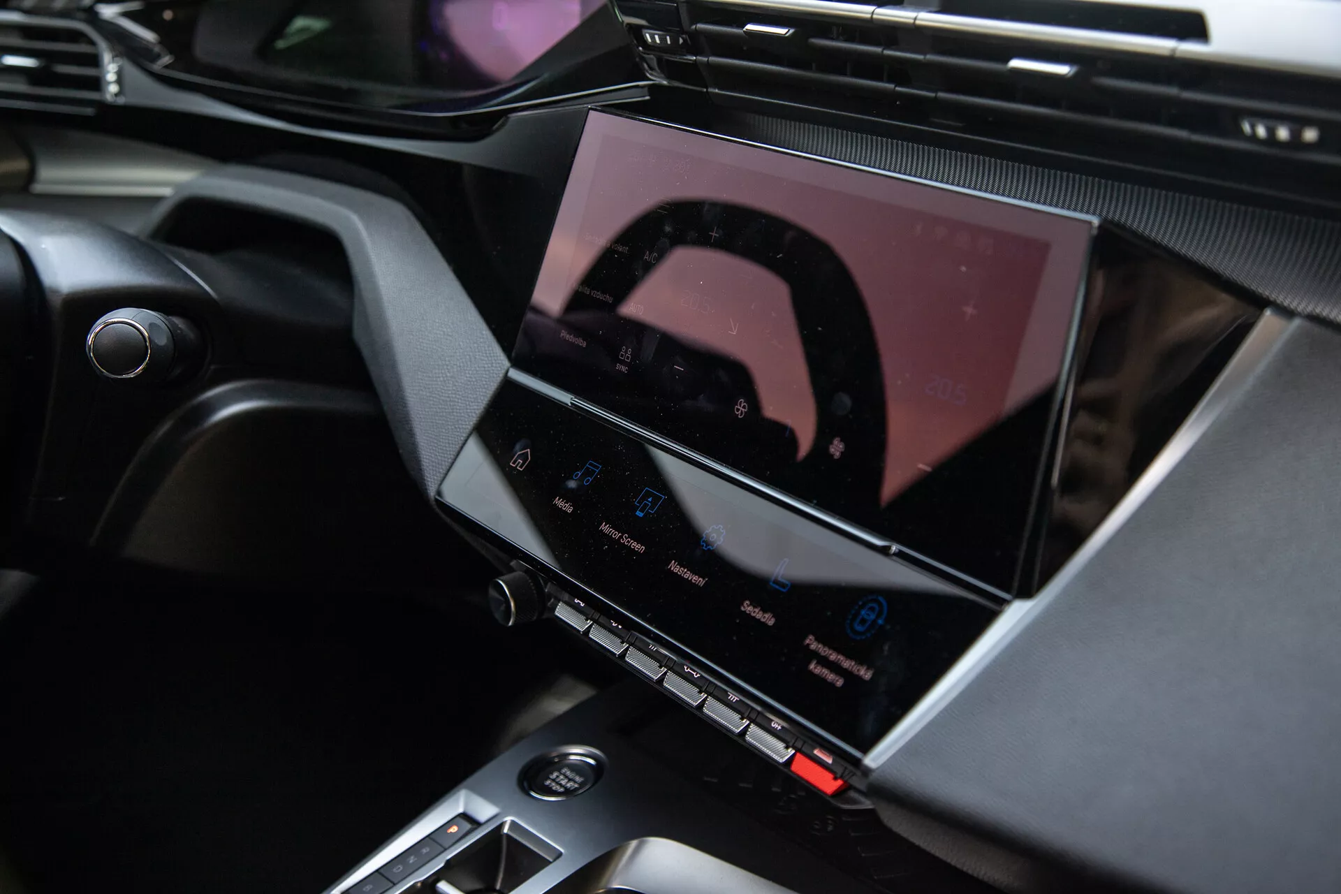 Interiör av Peugeot 408 2023 som visar mittkonsolen och det avancerade infotainmentsystemet med pekskärm, klimatkontrollknappar och snygga designaccents