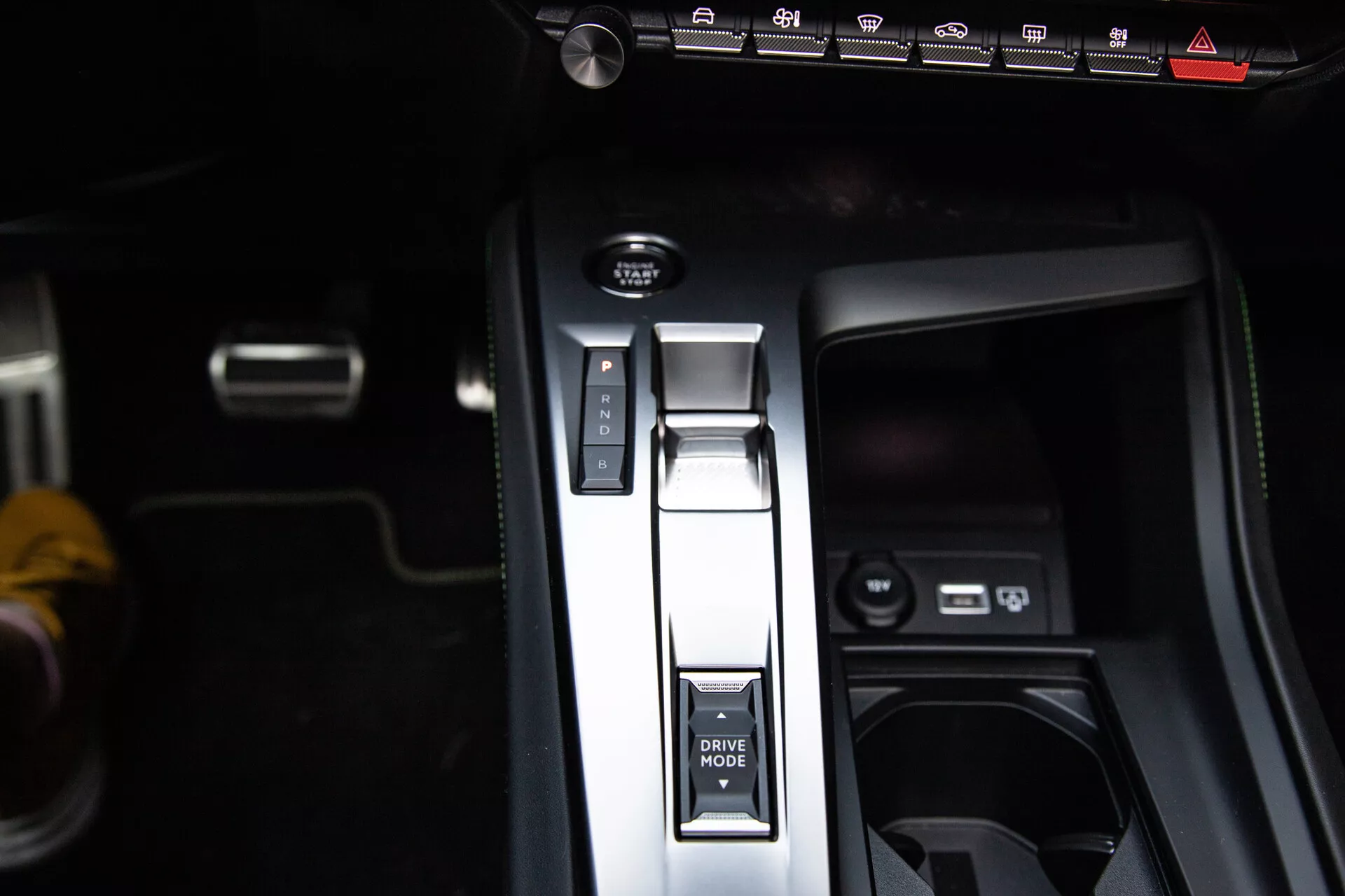 Närbild av mittkonsolen i Peugeot 408 2023 med växelspak i parkeringsläge, DRIVE MODE-knapp, elektronisk handbroms och USB-portar, som visar modern interiördesign.