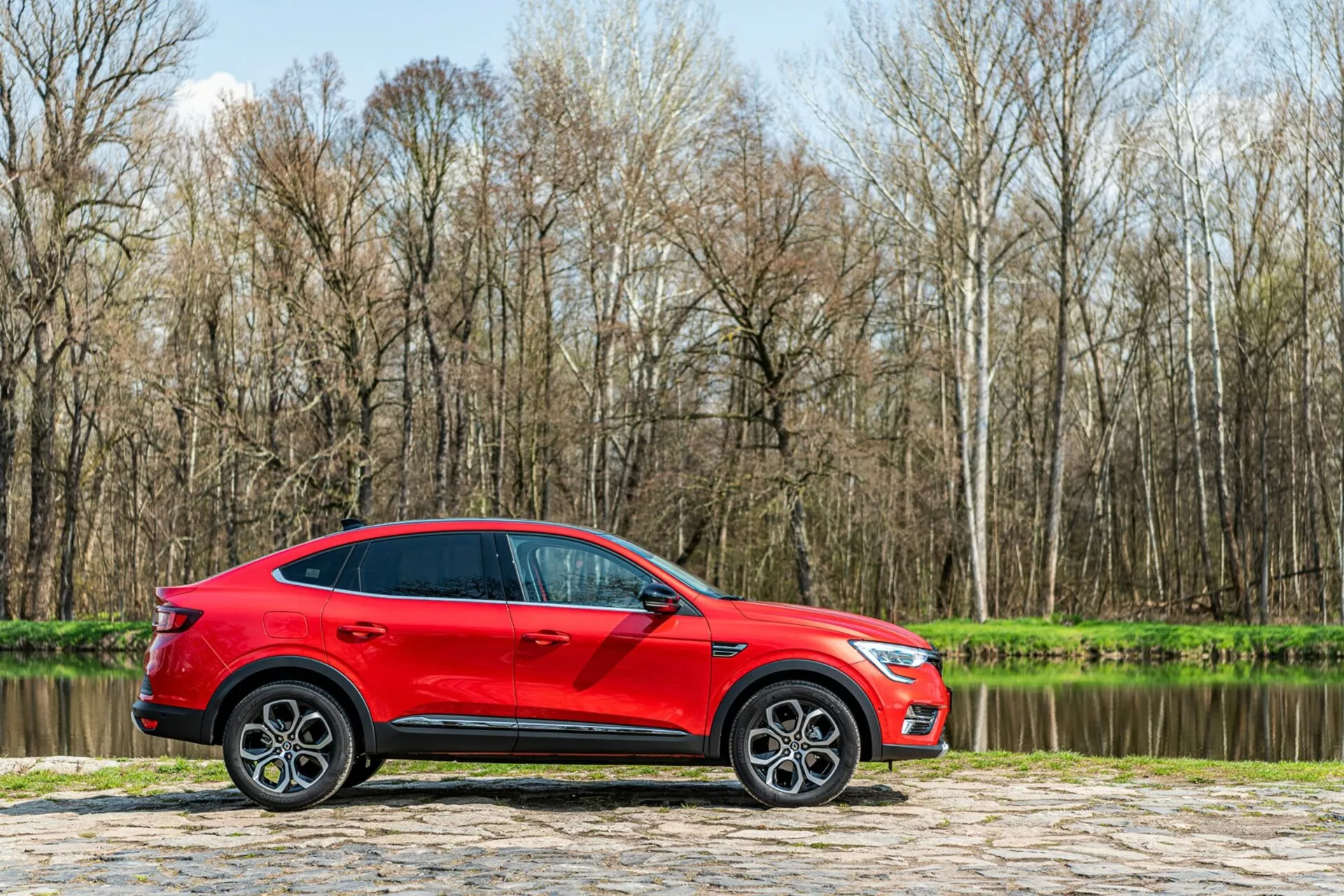 Främre vy av en Renault Arkana från 2021 med en snygg, modern design som har eleganta LED-strålkastare och en djärv, dynamisk grill, som visar upp sin sportiga men ändå sofistikerade charm.