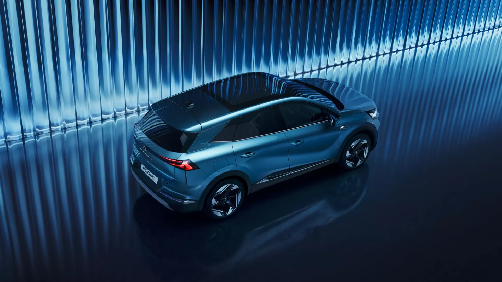 Högvinkelbild av en Renault Symbioz SUV 2024, som visar upp dess eleganta, aerodynamiska design med panoramatak och flerspakiga lättmetallfälgar, som reflekterar material av hög kvalitet och modern teknik i en studiouppsättning.