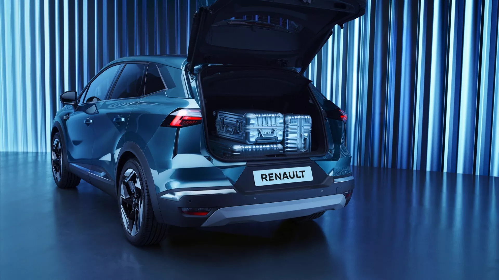 Bakre trekvartsvy av en första generationens Renault Symbioz 2024 SUV i mörkblått, som visar sin rymliga öppna bagageutrymme, distinkta LED-bakljus, krom 'RENAULT' namnskylt på bakluckan, modern design av bakre vindruta, flerkantiga aluminiumhjul och en studiobakgrund med futuristisk blåtonad bakgrund.