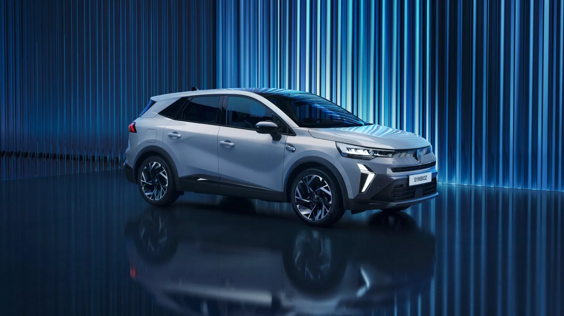 Digital studiobild av 2024 års Renault Symbioz 1:a generationen, modern SUV med slank och dynamisk design. Profilvy från en lätt framvinkel som visar sidoprofiler, fronten, grillen, strålkastarna, hjulen och sidospeglarna. Centralt placerad i ramen, låg vinkel fotografi som framhäver bilens kraftfulla hållning. Skarpa, vinklade strålkastare som antyder LED-teknik och dagsljus. Smal horisontell grill som betonar aerodynamik. Skulpterad karakterlinje som löper från framskärmen till baksidan för ett strömlinjeformat utseende. Flerekrade lättmetallfälgar förstärker det sportiga utseendet. Reflekterande yta under bilen och blå abstrakt digital bakgrund skapar en premium, futuristisk estetik möjliga indikerandes modern eller till och med elektrisk framdriftsteknik.