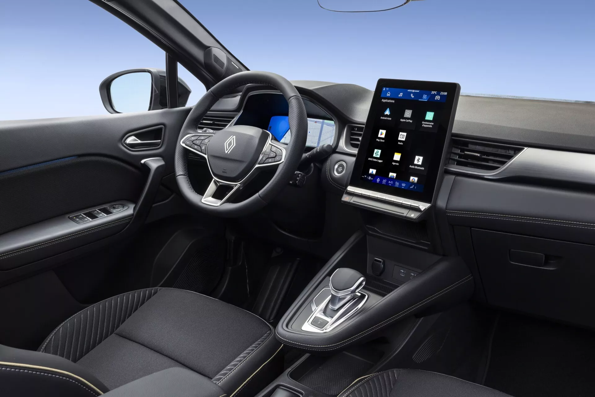 Interiörbild av Renault Symbioz 2024, första generationen, som framhäver den moderna främre hytten från den högra bakpassagerarens perspektiv. Funktioner inkluderar en multifunktionell ratt klädd i läder, ett vertikalt orienterat pekskärms infotainmentsystem som visar multimediala gränssnitt och en smidig mittkonsol med växelspak och körlägesväljare, vilket illustrerar avancerad uppkoppling och förarhjälpskontroller.
