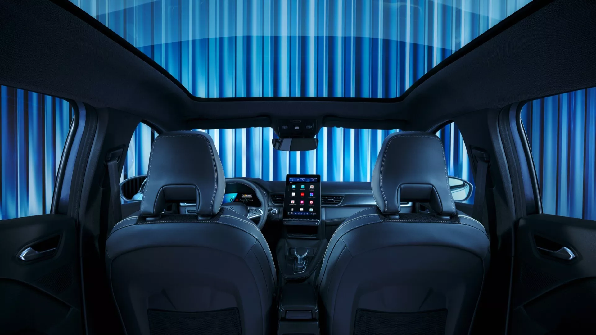 Vy från baksätet av interiören i Renault Symbioz 2024 första generationen, som visar upp den kompletta designen av kupén och avancerad teknik. Bilden framhäver två framsäten i läder med kontrasterande sömmar, en stor central pekskärm för infotainment, minimalistisk instrumentbräda med horisontella linjer, multifunktionell ratt, digital instrumentpanel och ambient belysning.
