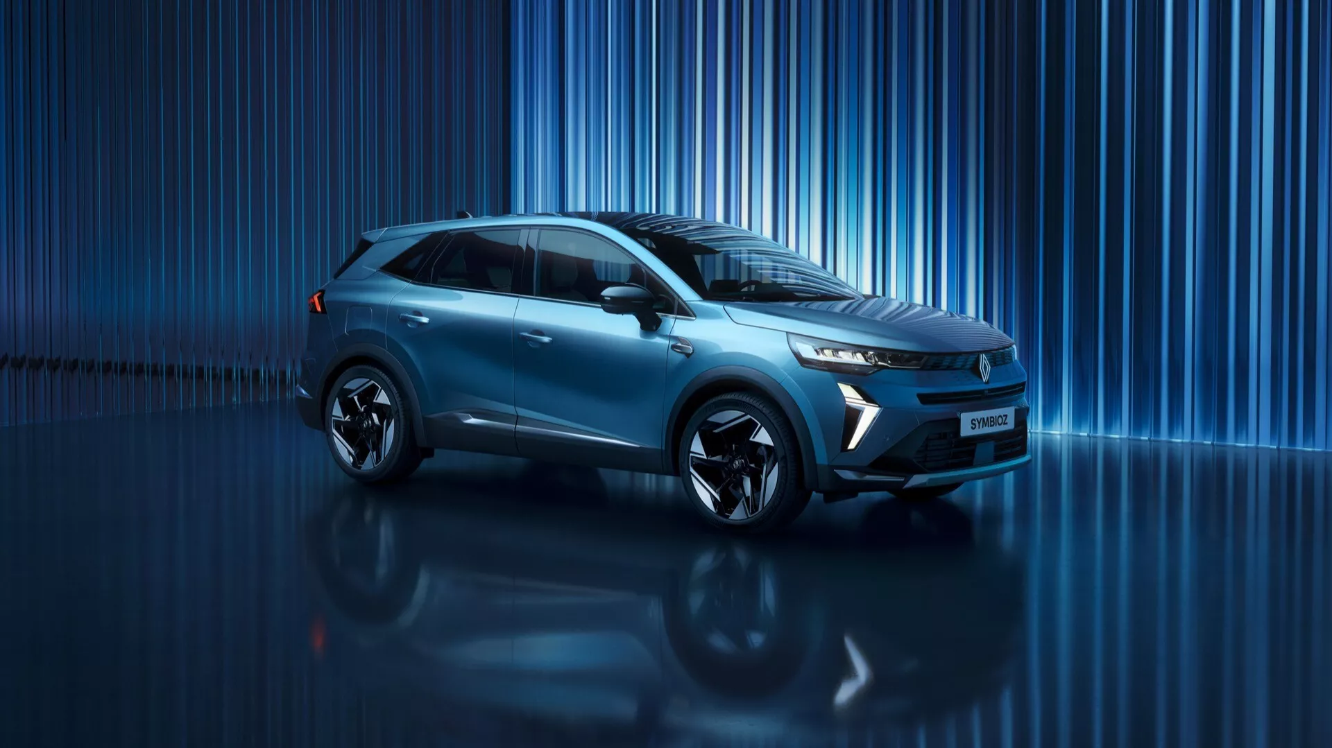 Bilden visar en modern SUV crossover med höjd markfrigång, sedd i en ungefär fyrtiofem graders vinkel. Bilen visar sin vänstra, främre kvadrant vilket ger en tydlig vy av både front och sidprofiler. Fronten har förmodligen en stiliserad grill och skarpa, vinklade strålkastare för en modern look. De försänkta områdena under strålkastarna kan vara dimljus eller luftintag. Huven är slät och tillför en modern design. Sidprofilen visar en stark skulderlinje, integrerade sidospeglar och fönster med sannolikt krom eller högblankt trim. De stora fälgarna är sportiga och mångekrade och den turkos eller ljusblå metalliclacken ger en glansig lyster. Bilen verkar vara i ett showroom med blankt golv som reflekterar fordonet. Bakgrunden består av vertikala blå linjer som förstärker känslan av rörelse och digital teknik. Designen antyder avancerad aerodynamik och det kan vara ett hybrid- eller helt elektriskt fordon utrustat med LED-belysning, förarassistanssystem, anslutningsalternativ och infotainmentsystem.
