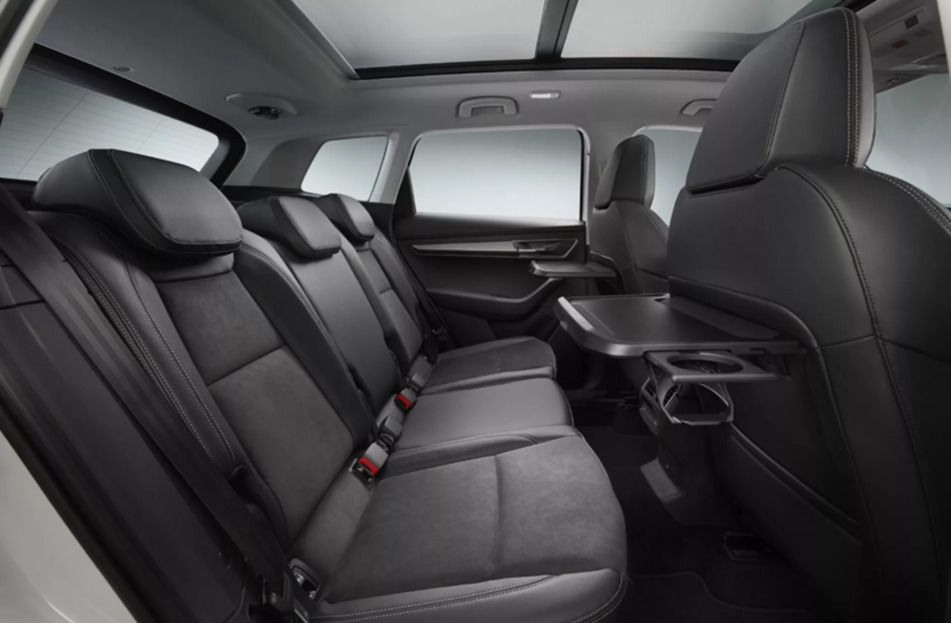 Interiör av Skoda Karoq 2017 visar ett rymligt och bekvämt baksäte med premium tvåfärgad klädsel, bakre klimatkontroll, fällbart armstöd med dryckeshållare och underhållningssystem