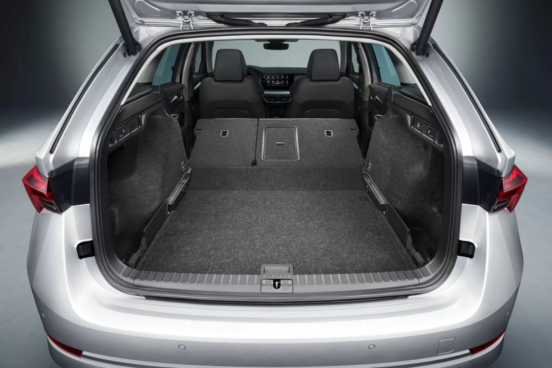 2017 Skoda Octavia hatchback öppet bagageutrymme som visar rymligt lastutrymme med nedfällda baksäten, platt lastgolv, mattklädsel, förankringspunkter för säker förvaring och möjliga avancerade tekniska funktioner såsom LED-belysning