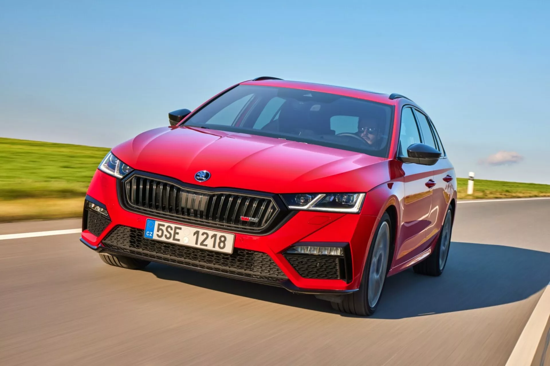 Skoda Octavia RS hatchback 2017 i dynamisk rörelse på en asfalterad väg, visar upp en sportig röd design med svarta accenter, LED-strålkastare och avancerade tekniska funktioner inklusive ADAS och panoramatak
