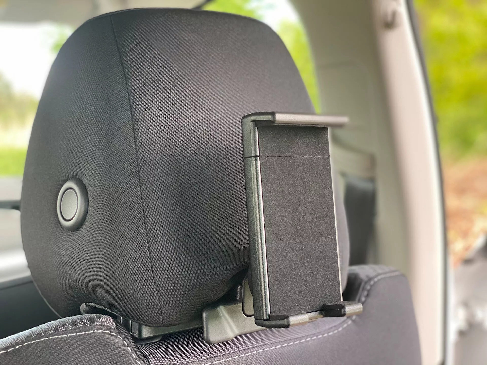 Närbild av nackstödet i en Škoda Octavia 2020 (Octavia-Limousine) från en invändig sidovinkel, som framhäver nackstödets justeringsmekanism och klädhängarfäste. Nackstödet har ett tyg- eller läderfinish med ett subtilt mönster, med fokus på komfort och design.