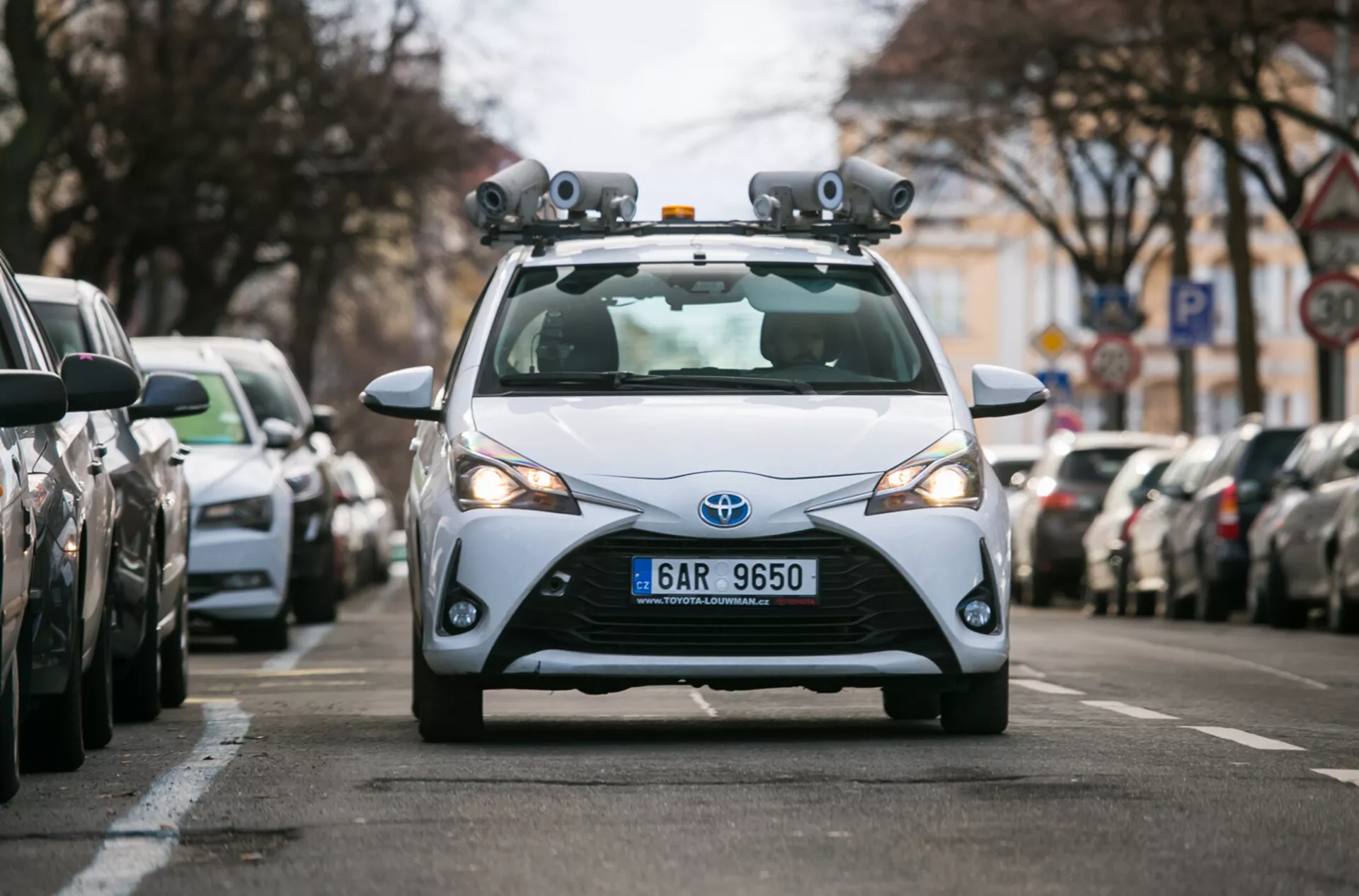 2017 års Toyota hatchback utrustad med LiDAR-sensorer och kameror för teknik för autonom körning, fångad från ett frontperspektiv på en stadsgata