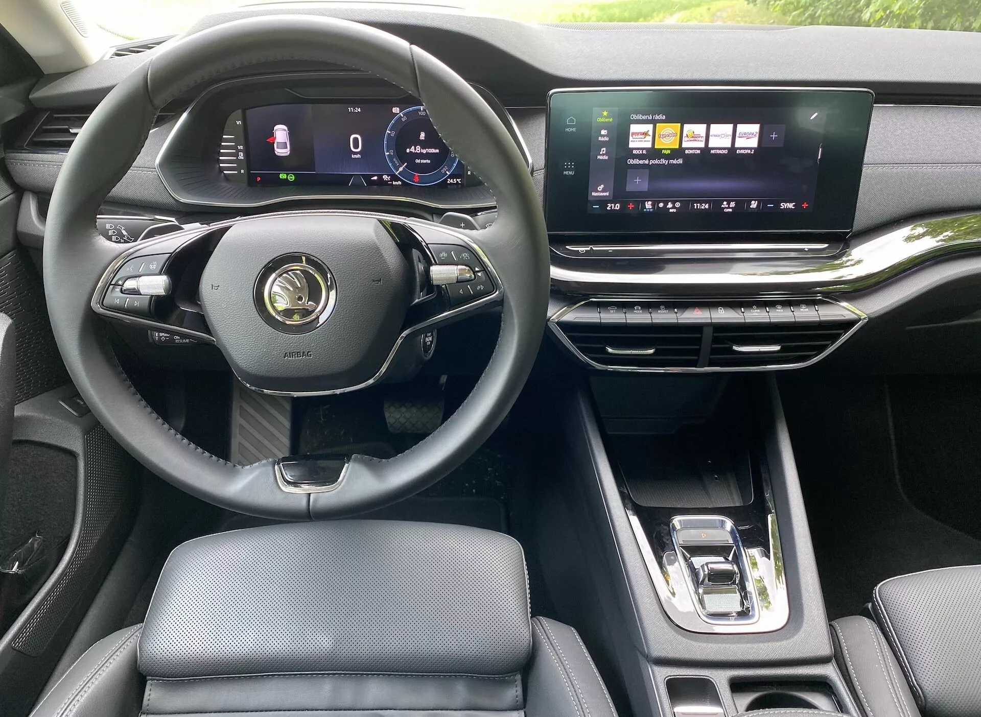 Interiör av en modern 2020 års Skoda Octavia Limousine, som lyfter fram förarens perspektiv med treekrad multifunktionsratt, digital instrumentpanel, bred horisontell pekskärm för infotainmentsystemet, eleganta luftventiler och automatisk växelspak. Den lyxiga interiören har lädersäten och metalliska accenter.
