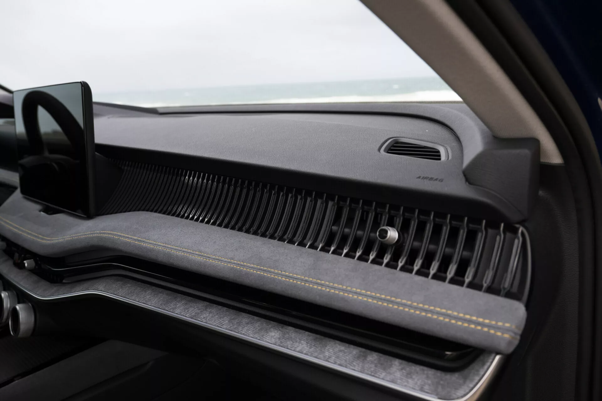 Närbild inuti Skoda Superb Combi 2024 med fokus på passagerarens instrumentbräda med minimalistisk design, premium luftventil och handskfack
