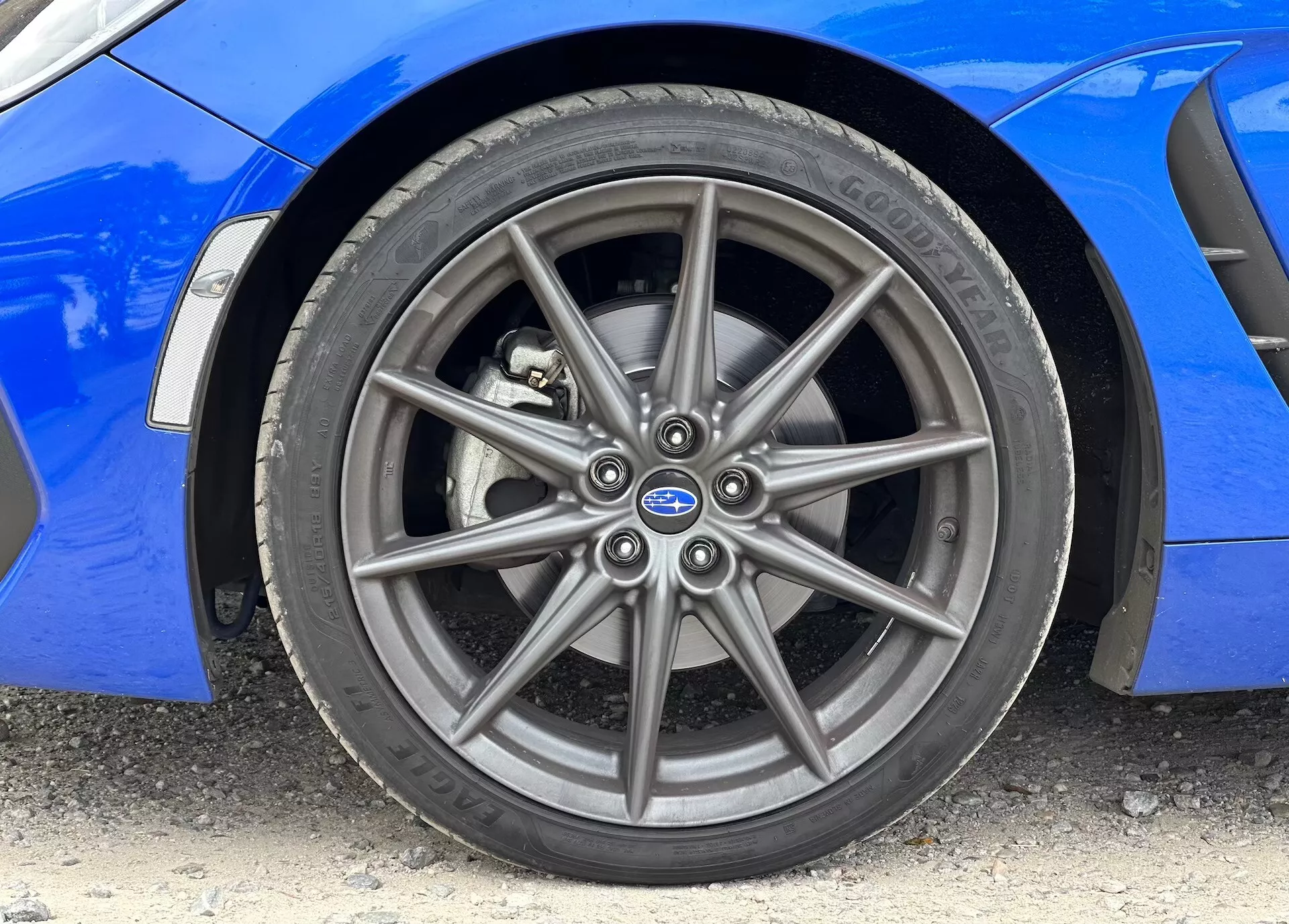Närbild på Subaru BRZ 2023 som visar det främre aluminiumsfälget och Continental-däcket, med synlig vibrerande blå kaross