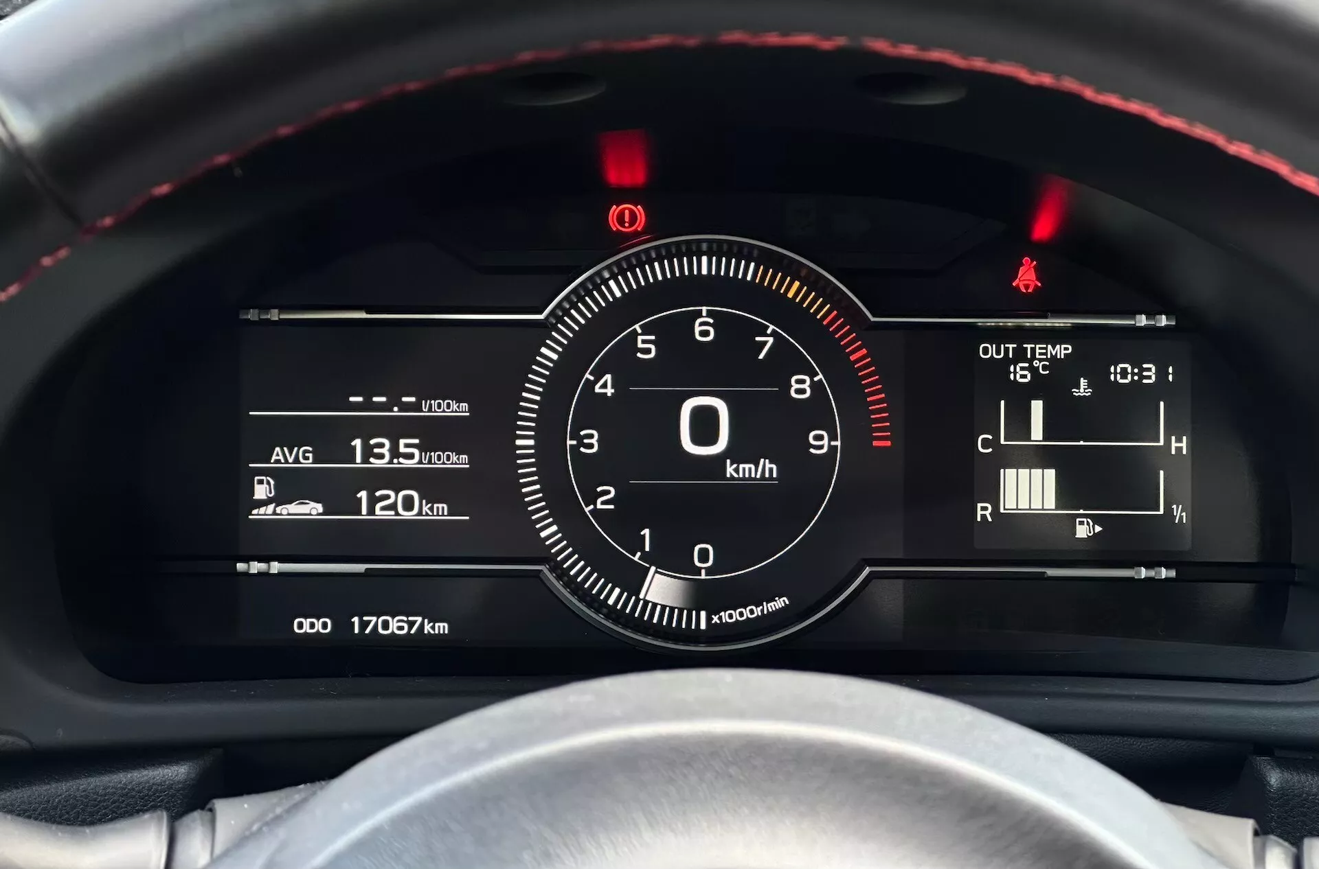 Detaljerad vy av instrumentklustret i Subaru BRZ 2023 med fokus på hastighetsmätaren och andra mätare från förarens perspektiv, med rödsydd ratt, kombination av digitala och analoga mätare och teknologiska indikatorer som bränsleeffektivitet, temperatur och mätaravläsningar.