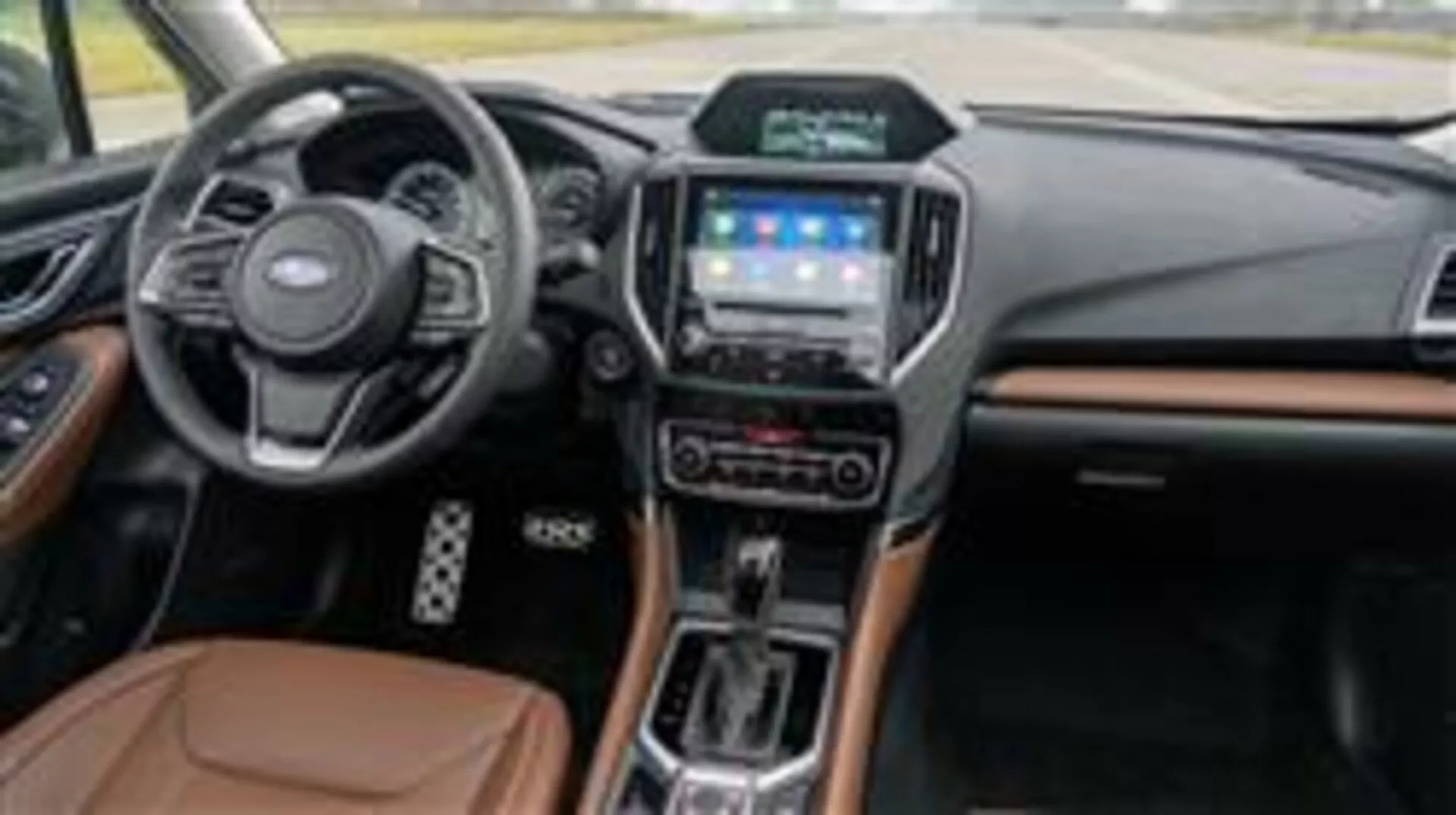 Interiör av Subaru Forester 2015 med instrumentbräda, multifunktionsratt, pekskärms infotainmentsystem, väljare för automatisk växellåda och lyxiga materialaccentier sedd från passagerarsidan