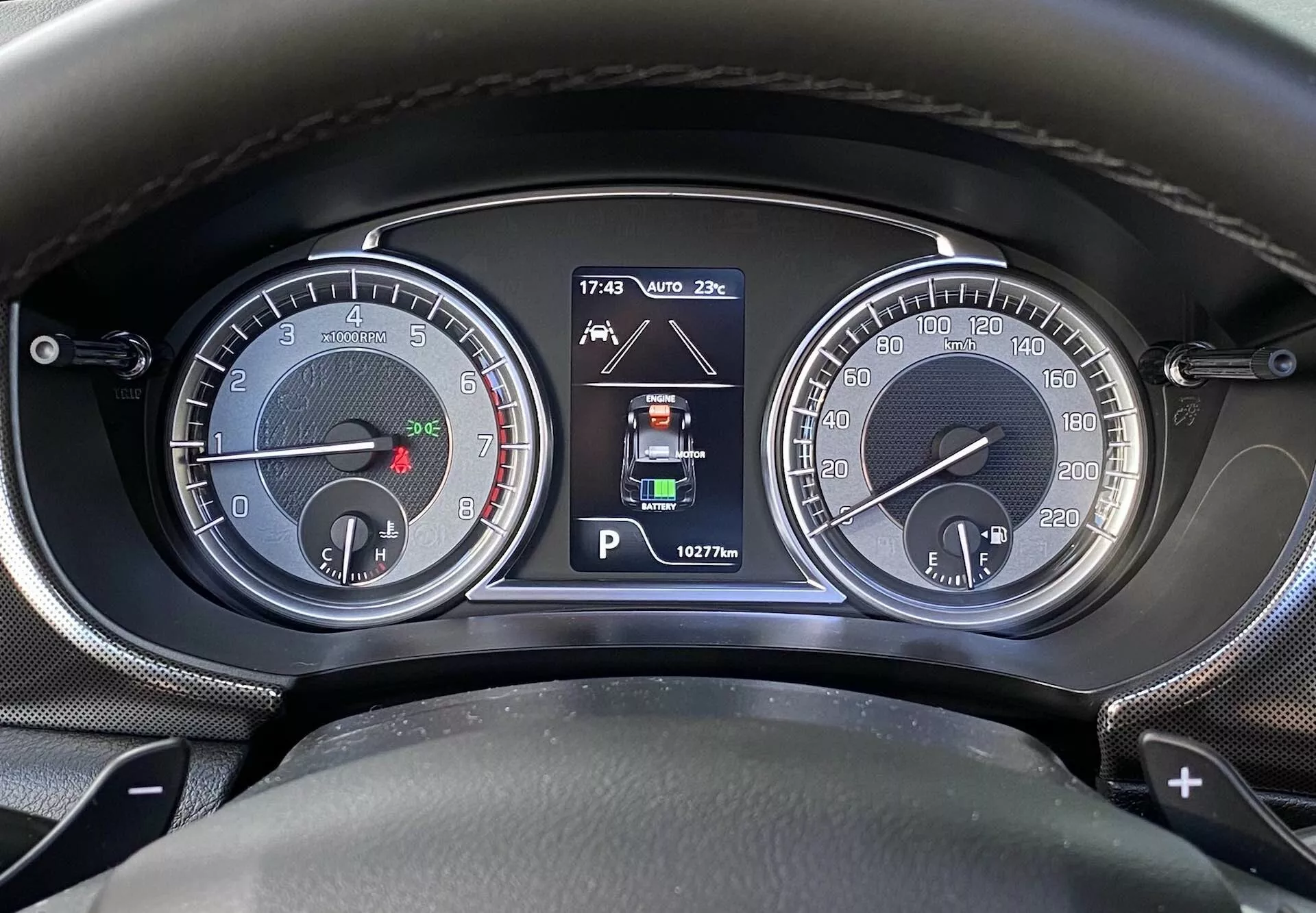 Närbild av instrumentpanelen/dashbord Suzuki Vitara 2018 från förareens perspektiv. Bilden innehåller två analoga mätare, inklusive en varvräknare (upp till 7000 rpm) med en liten bränslemätare och en hastighetsmätare (upp till 260 km/h) med en liten motortemperaturmätare. En central digital display visar parkeringsläge, parkeringsassistansindikatorer, omgivningstemperatur (20°C), tid (17:43) och mätarställning (162776 km). Växelspaksmarkeringarna antyder en automatisk eller halvautomatisk växellåda.