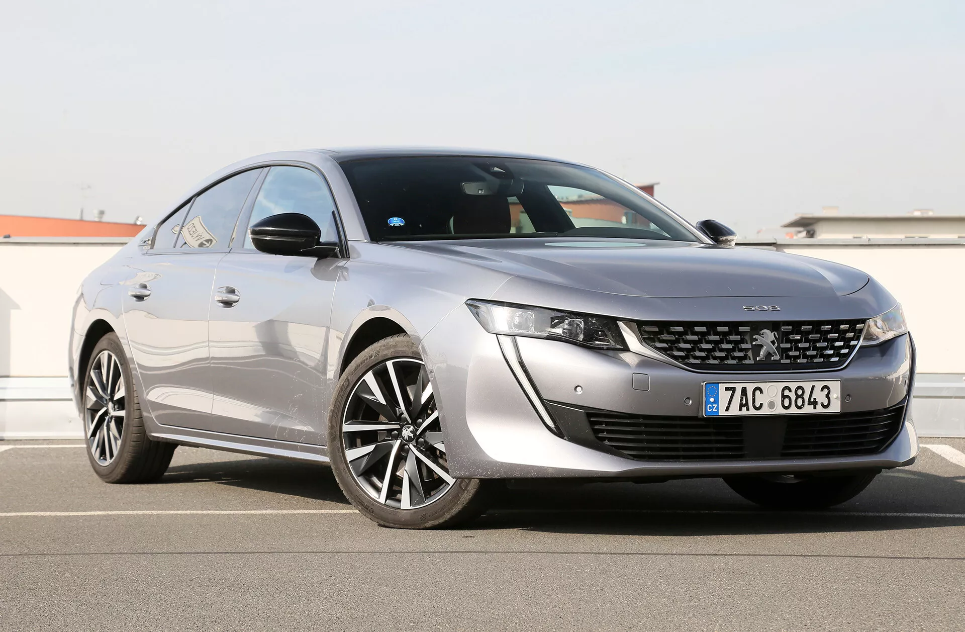 2019 Toyota Camry Limousine visas från en trekvarts framåtvinkel som visar dess slanka LED-strålkastare, distinkta frontgrill med centralt märke, aerodynamiskt designad huva och sidoprofil med stora flerspakiga aluminiumhjul, glänsande lack och coupé-liknande taklinje