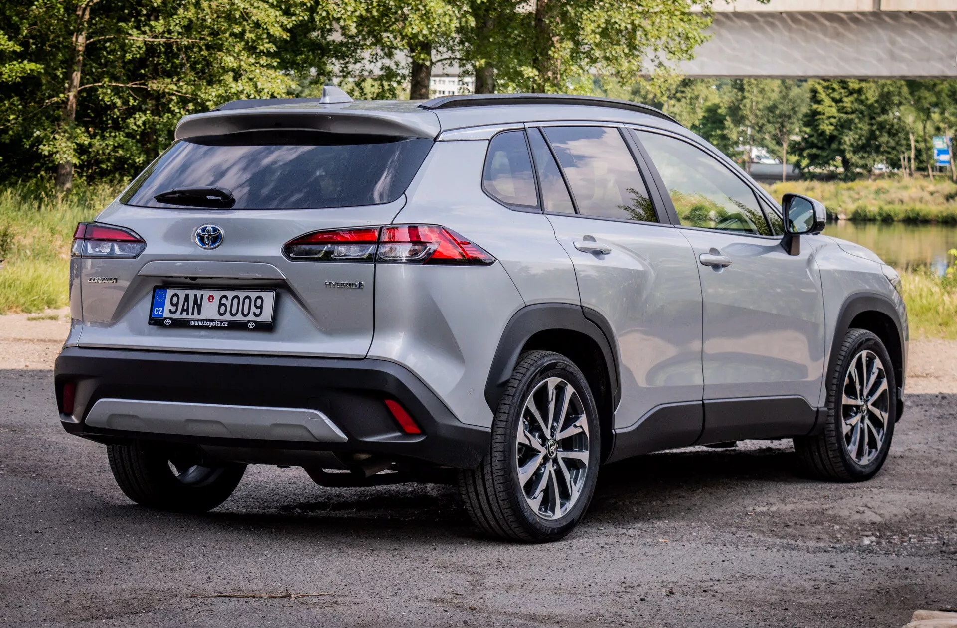 Hybrid kompakt SUV Toyota Corolla Cross 2022 som visar avancerade LED-bakljus, legeringshjul och säkerhetsfunktioner från en tre fjärdedels bakifrån utsikt.
