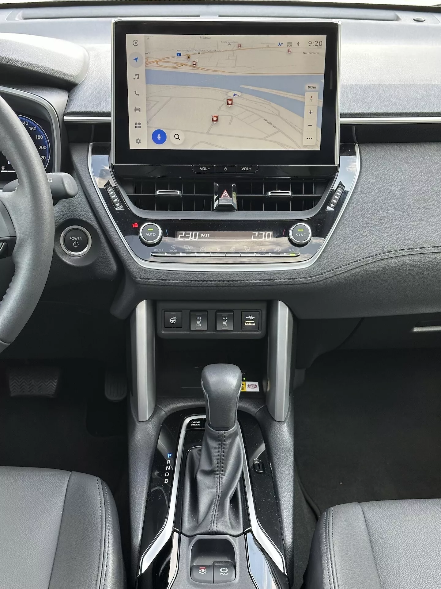 Interiör för Toyota Corolla Cross 2022 med pekskärmsunderhållningssystem med GPS-navigation, tvåzons klimatkontroll, CD-fack, knappar för medie- och telefonkontroll, modern automatväxelspak och läderaccent på mittkonsolen och instrumentbrädans design