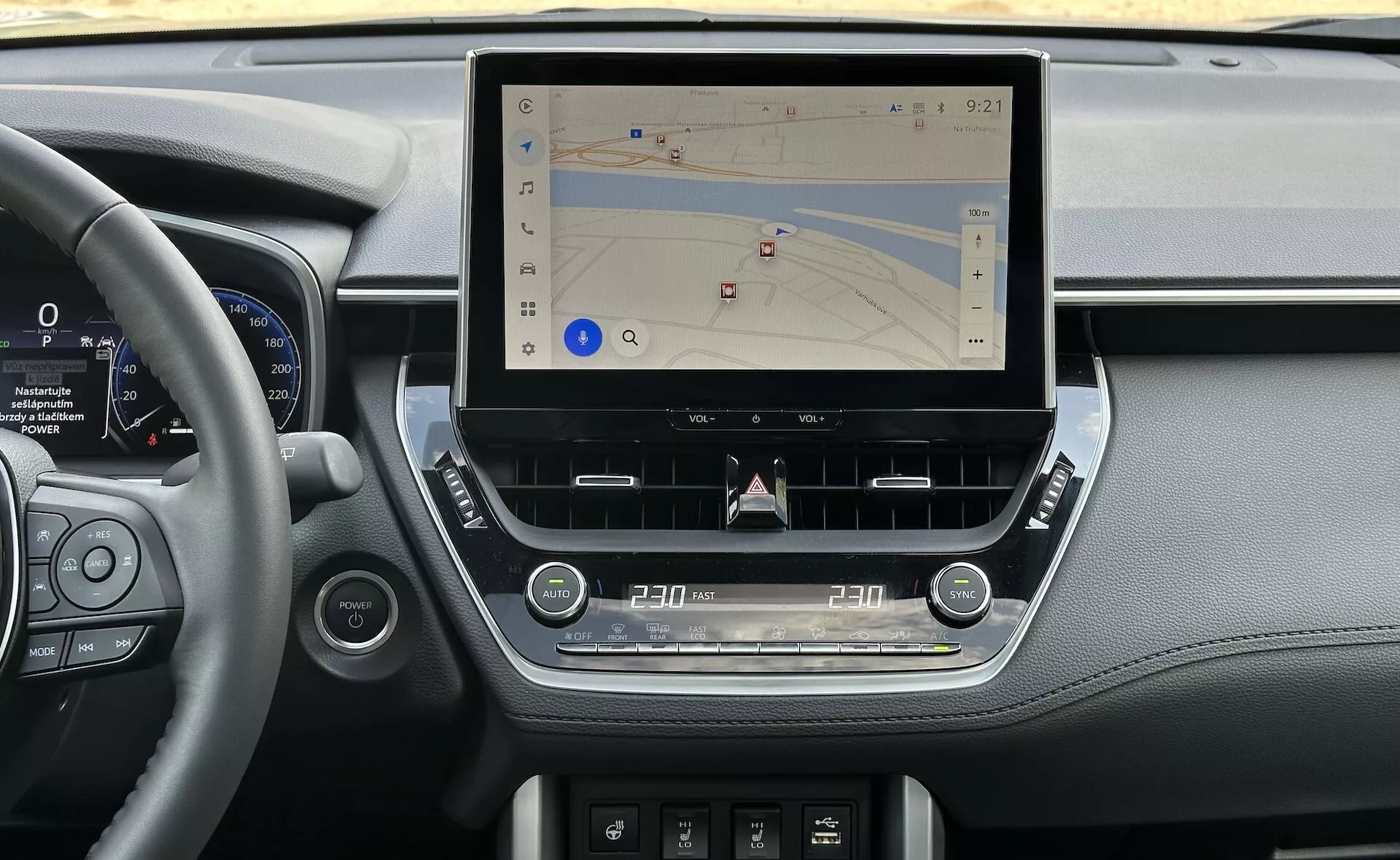 Interiör av Toyota Corolla Cross 2022 som visar en modern mittkonsol med en stor, vertikal pekskärm för navigering, omgiven av eleganta instrumentpanelsdelar som inkluderar läderdetaljer, digital instrumentkluster bredvid ratten och ergonomiska taktila kontroller för klimat och ljud, inställda i naturligt ljus.