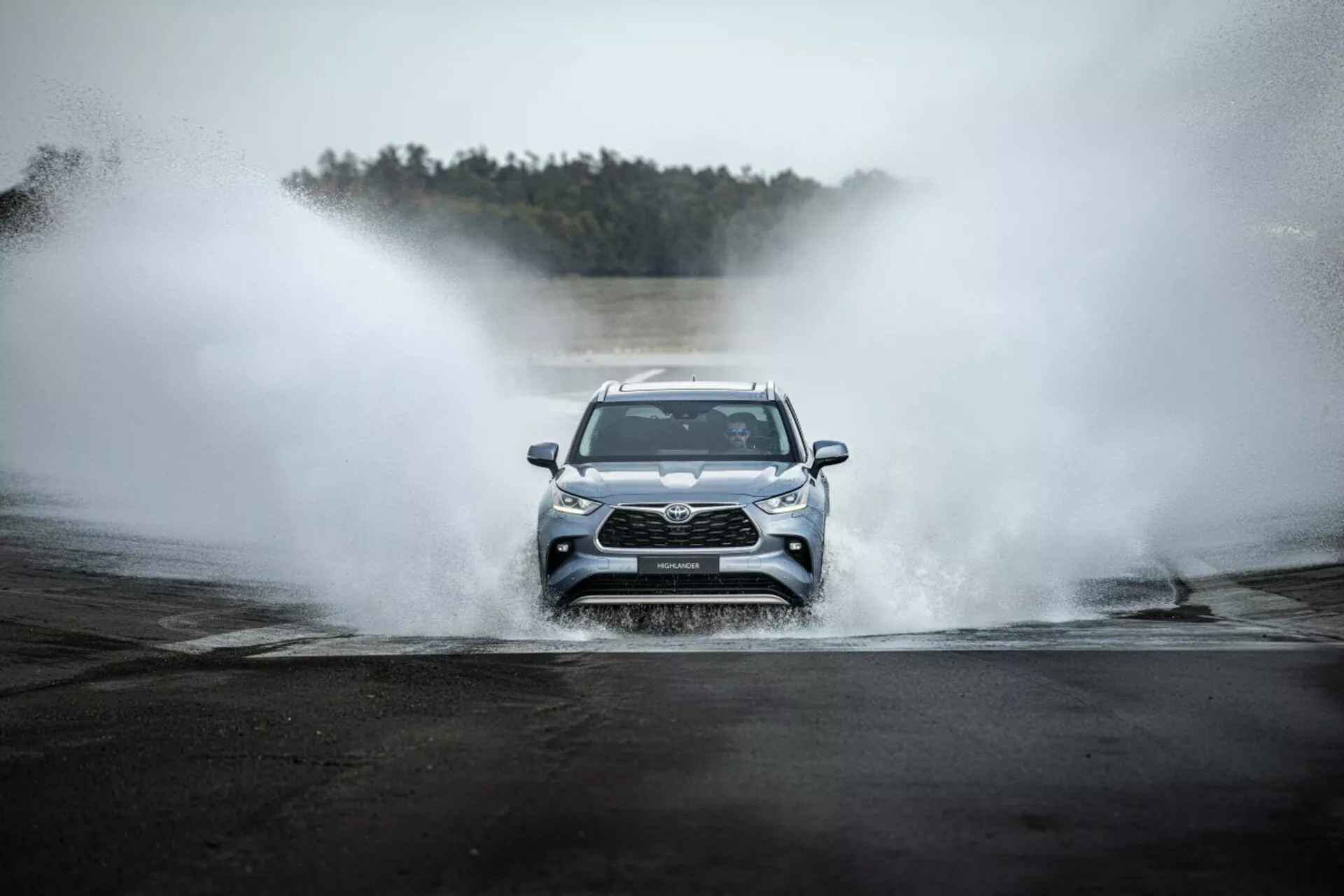 Toyota Highlander 2021 som kör rakt fram genom vatten, visar främre grillen, LED-strålkastare och sportig design i ett äventyrligt sammanhang