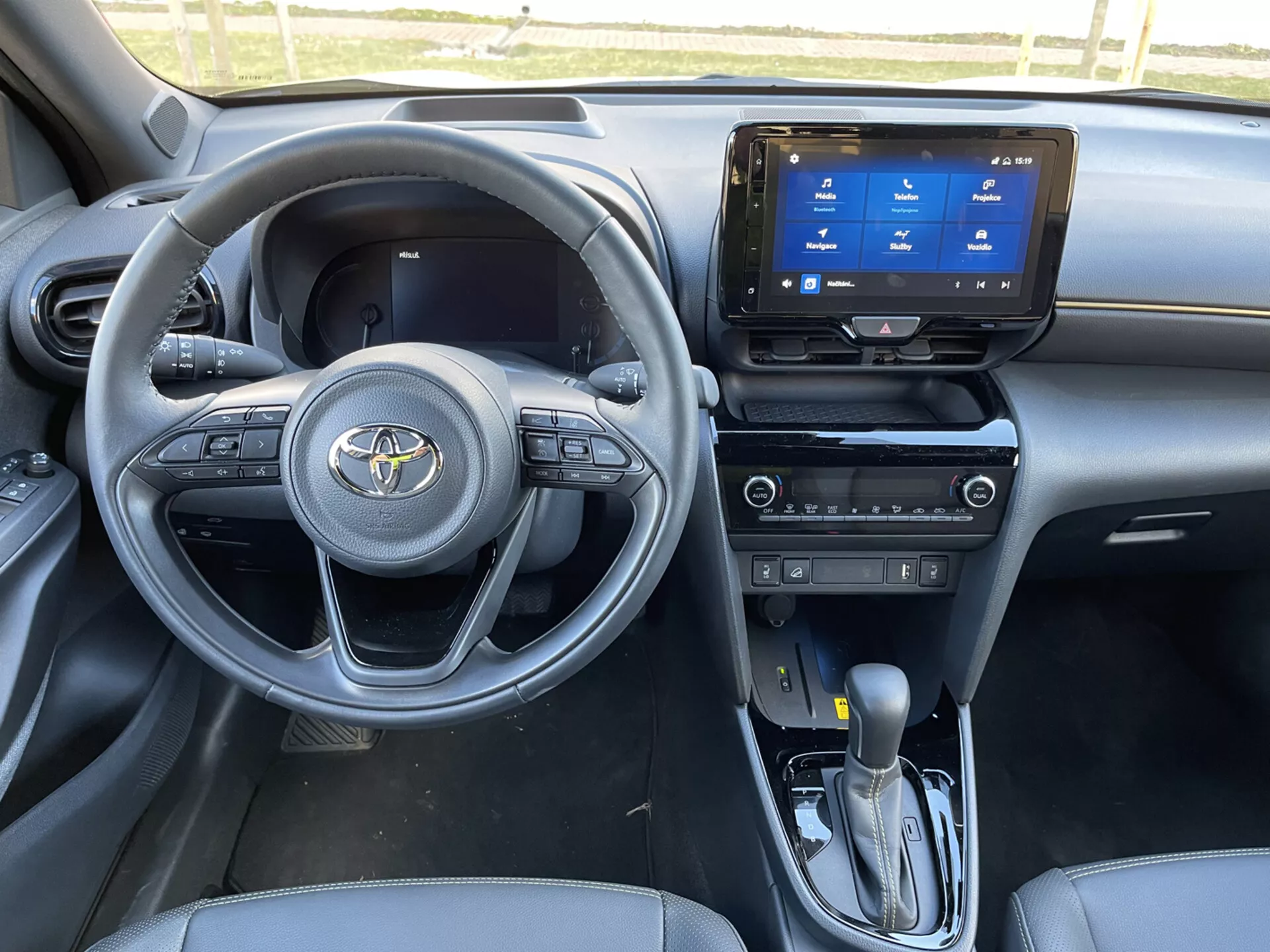 2021 Toyota Yaris Cross interiörvy från passagerarsidan fram, visar instrumentbrädan, ratten med monterade kontroller, pekskärmsinfotainmentsystem, automatisk växelspak och eleganta mörka tematsits- och designfunktioner