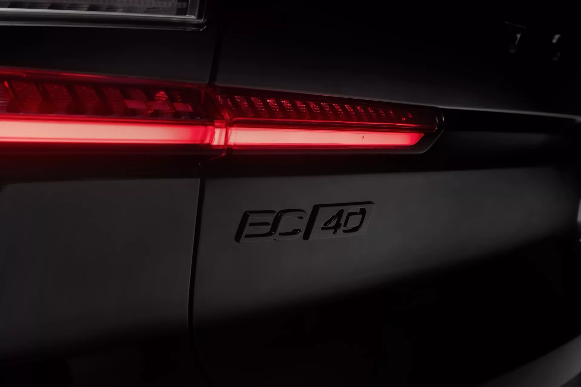 Detaljerad vy av bakre delen av Volvo EC40 2024 med LED-bakljus och 'FC 4D' modellmärkning, som visar modern bilkonstruktion och högkvalitativa egenskaper