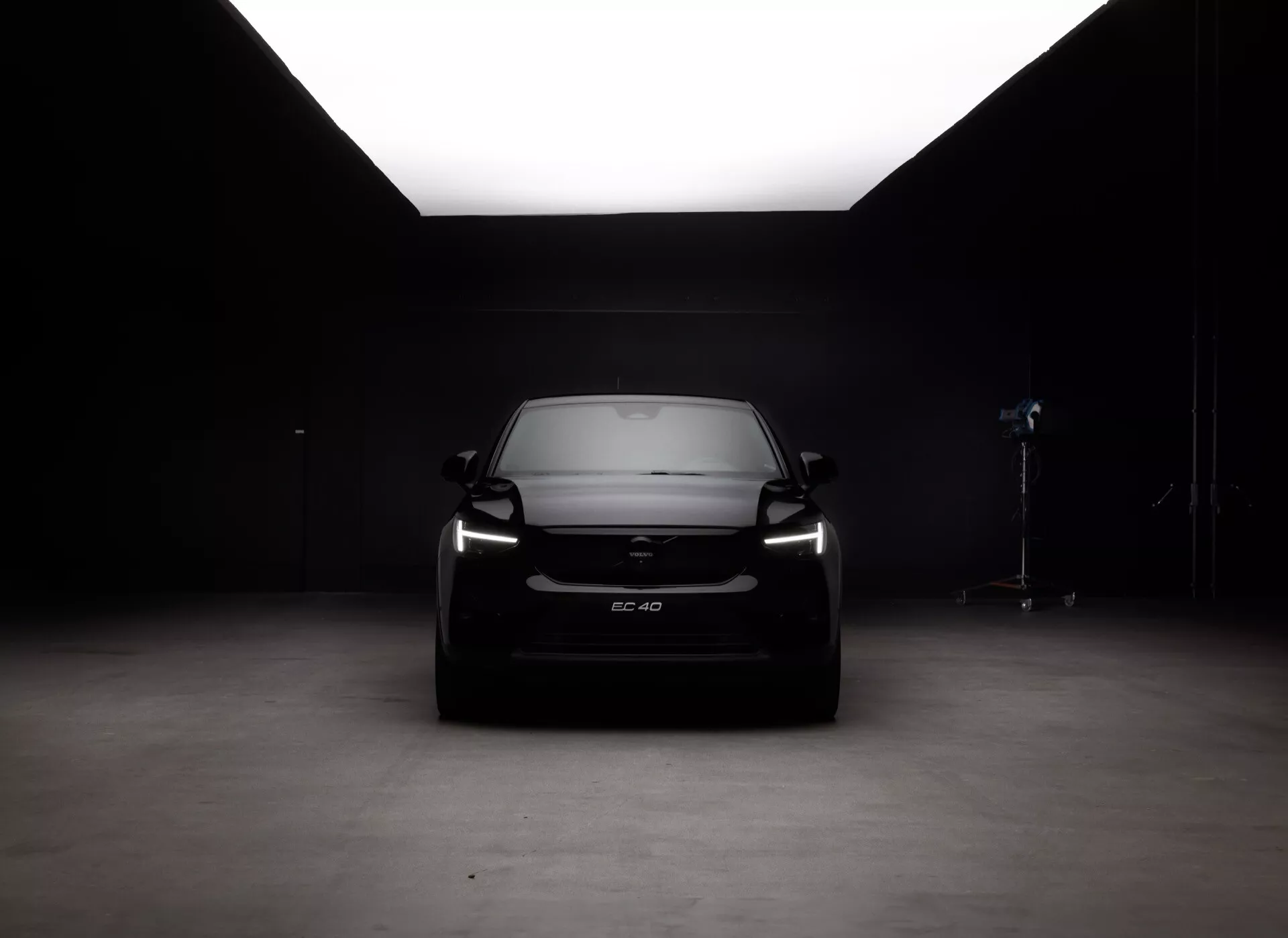 Framifrån vy av Volvo EC40 1:a generationen 2024 i professionell studioinställning, som visar grill, strålkastare och Volvo-emblem med högkontrastbelysning