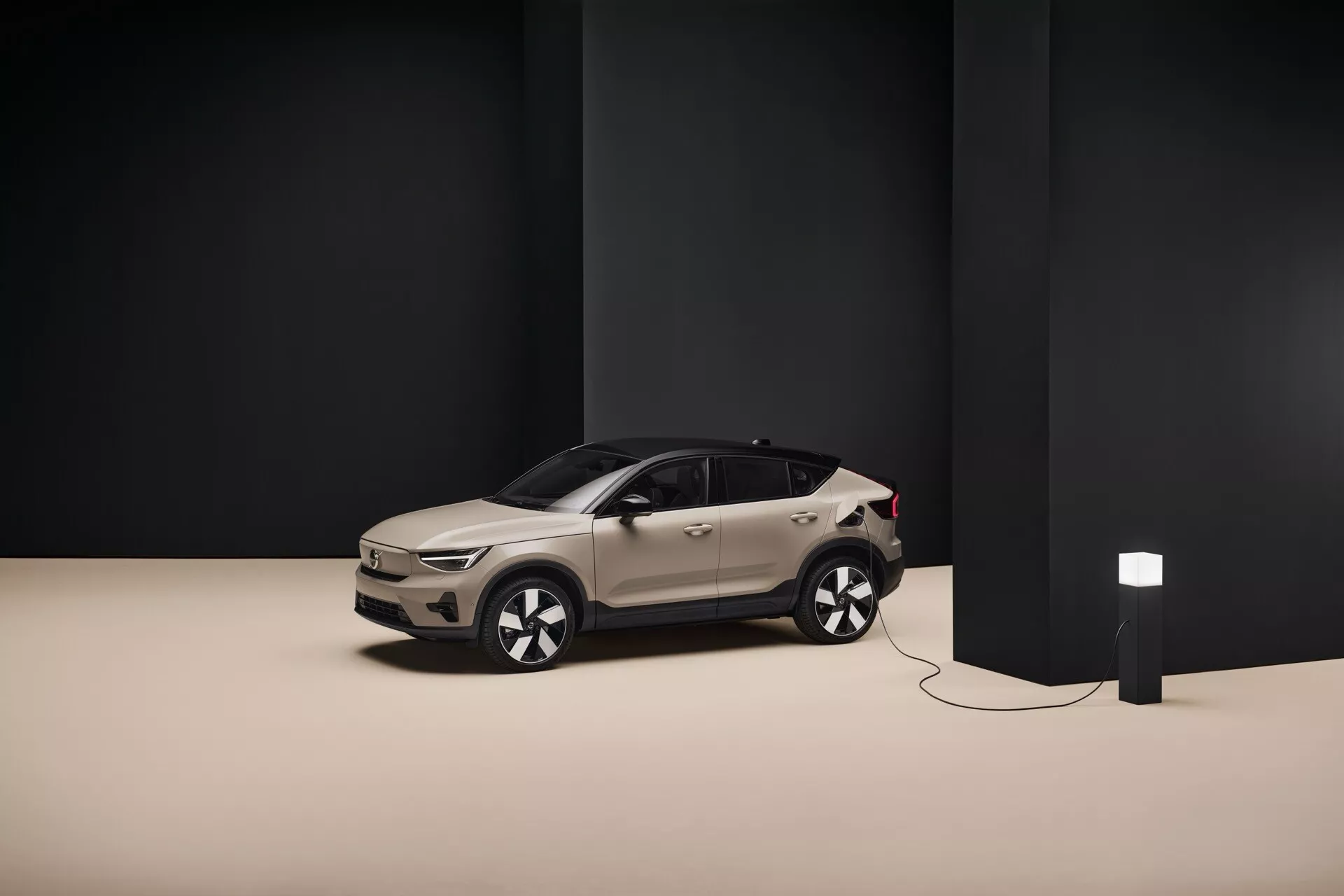 2024 Volvo EC40 1:a generationens moderna elektriska crossover SUV i studioinställning, visar grill, strålkastare, hjul och snygg sidokontur med laddningsenhet ansluten